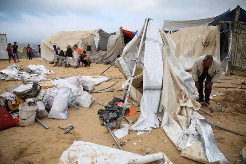 Palestinians inspect the damage at the site of an Israeli strike on a tent camp sheltering displaced people, amid the ongoing Israel-Hamas conflict, in Al-Mawasi area in Khan Younis, in the southern Gaza Strip, Tuesday.