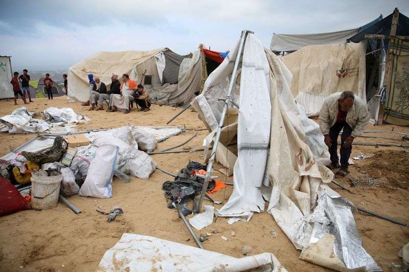 Palestinians inspect the damage at the site of an Israeli strike on a tent camp sheltering displaced people, amid the ongoing Israel-Hamas conflict, in Al-Mawasi area in Khan Younis, in the southern Gaza Strip, Tuesday.