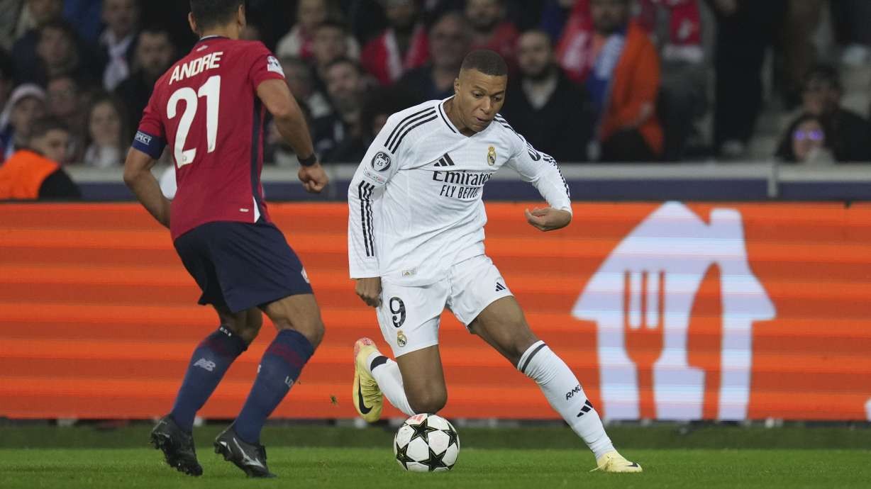 Real Madrid's Kylian Mbappe, right, dribbles the ball past Lille's Benjamin Andre during the Champions League opening phase soccer match between Lille and Real Madrid at the Stade Pierre Mauroy in Villeneuve-d'Ascq, outside Lille, France, Wednesday, Oct. 2, 2024.