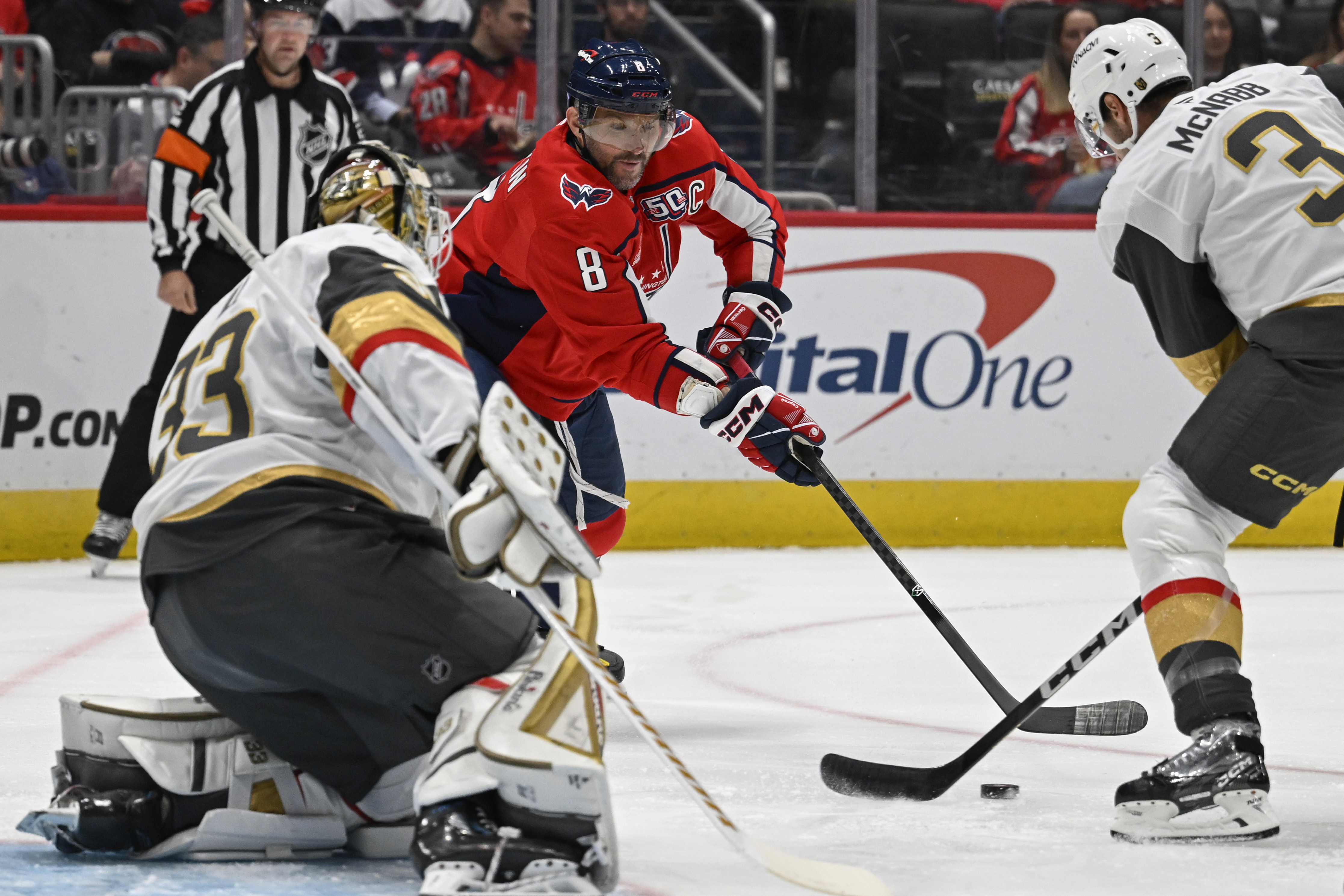Washington Capitals left wing Alex Ovechkin, center, attempts a shot against Vegas Golden Knights goaltender Adin Hill, left, and Golden Knights defenseman Brayden McNabb (3 ) during the first period of an NHL hockey game Tuesday, Oct. 15, 2024, in Washington.