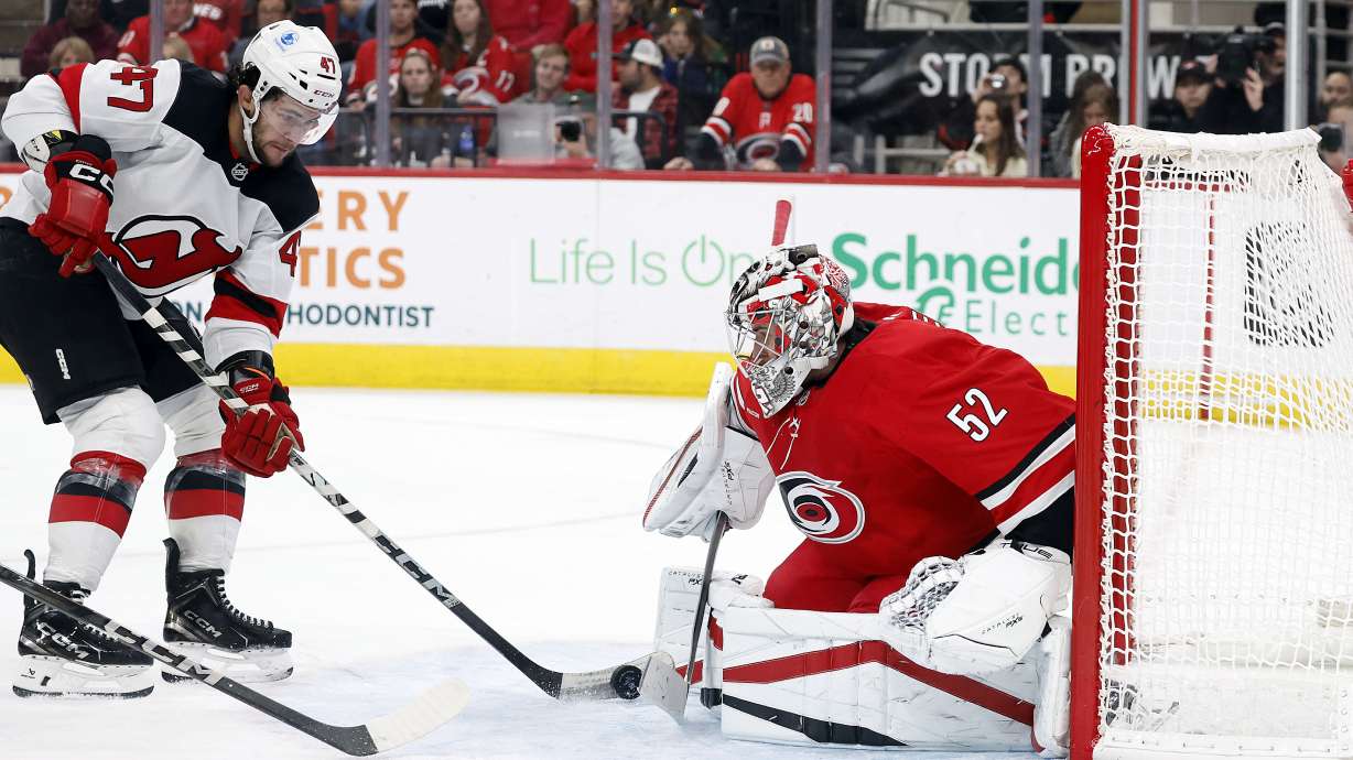 Carolina Hurricanes goaltender Pyotr Kochetkov (52) blocks the shot of New Jersey Devils' Paul Cotter (47) during the third period of an NHL hockey game in Raleigh, N.C., Tuesday, Oct. 15, 2024.