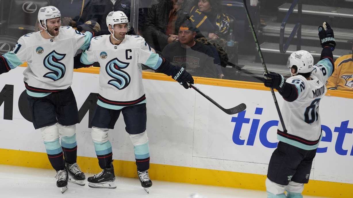 Seattle Kraken right wing Jordan Eberle, center, celebrates his goal with center Shane Wright (51) and defenseman Brandon Montour (62) during the third period of an NHL hockey game against the Nashville Predators, Tuesday, Oct. 15, 2024, in Nashville, Tenn.