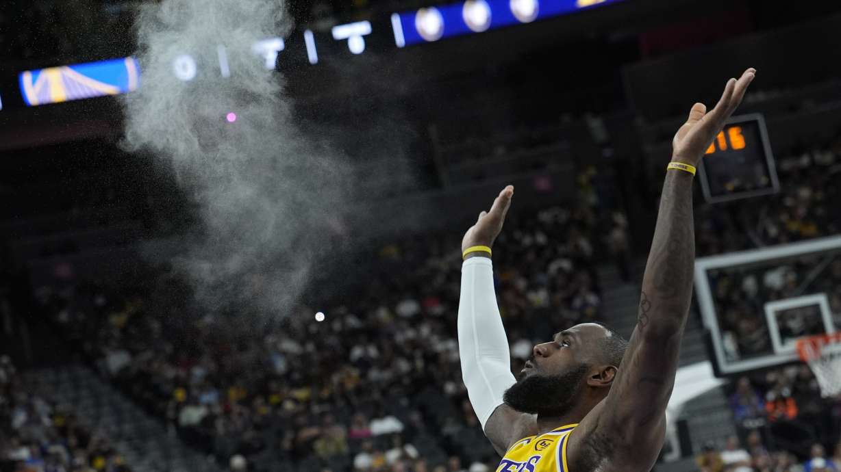 Los Angeles Lakers forward LeBron James (23) tosses chalk into the air before a NBA preseason basketball against the Golden State Warriors, Tuesday, Oct. 15, 2024, in Las Vegas.