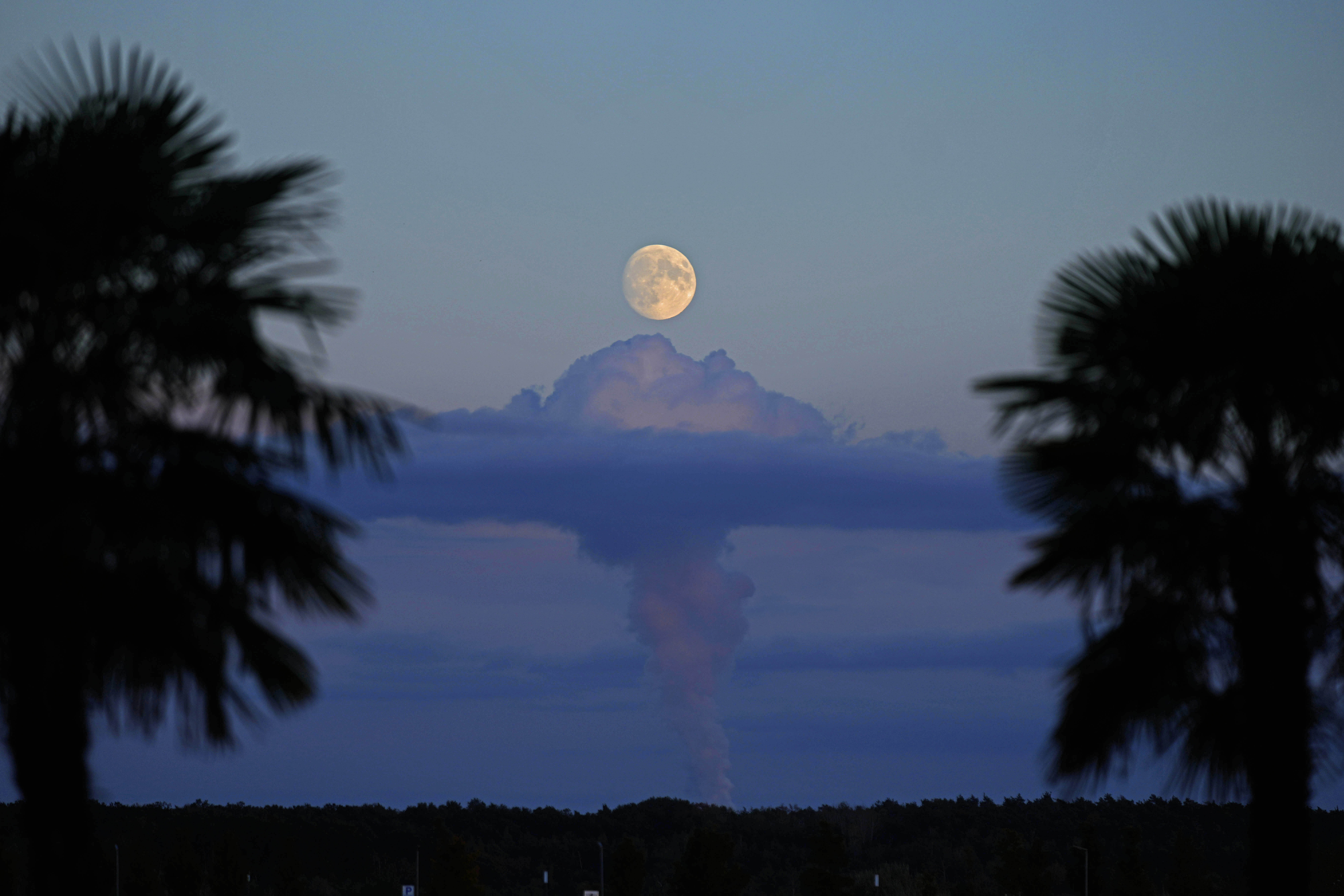 Steam rises from cooling towers of a power plant as the moon rises near Senftenberg, Germany, Tuesday. October's supermoon is the closest of the year and it's teaming up with a comet for a rare stargazing two-for-one.