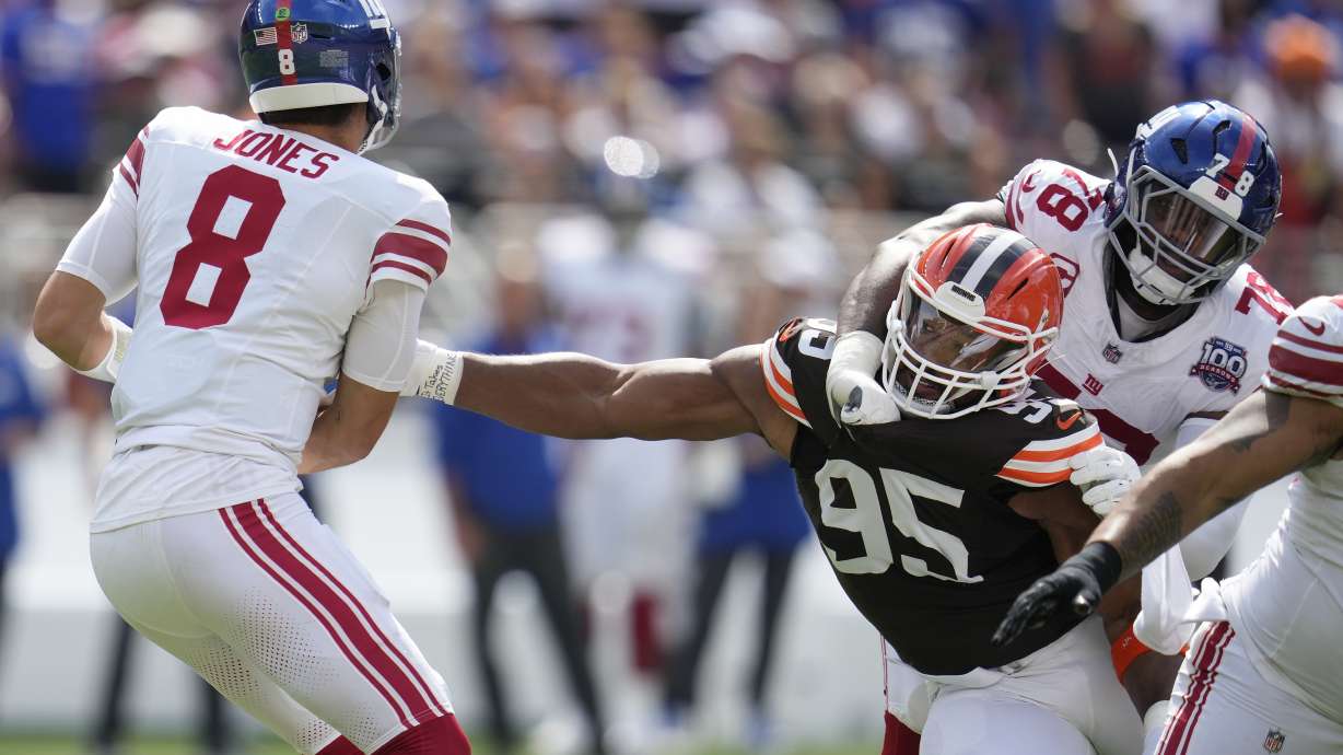 Cleveland Browns defensive end Myles Garrett (95) reaches for New York Giants quarterback Daniel Jones (8) while being blocked by offensive tackle Andrew Thomas (78) during the first half of an NFL football game, Sunday, Sept. 22, 2024 in Cleveland.