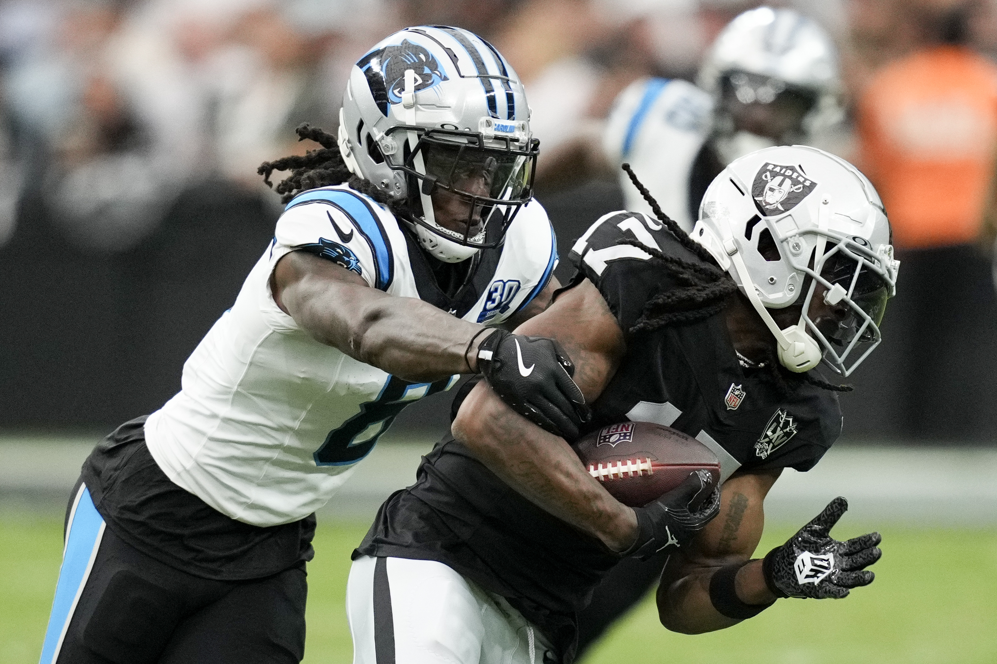Las Vegas Raiders wide receiver Davante Adams is tackled by Carolina Panthers cornerback Jaycee Horn during the first half of an NFL football game, Sunday, Sept. 22, 2024, in Las Vegas.