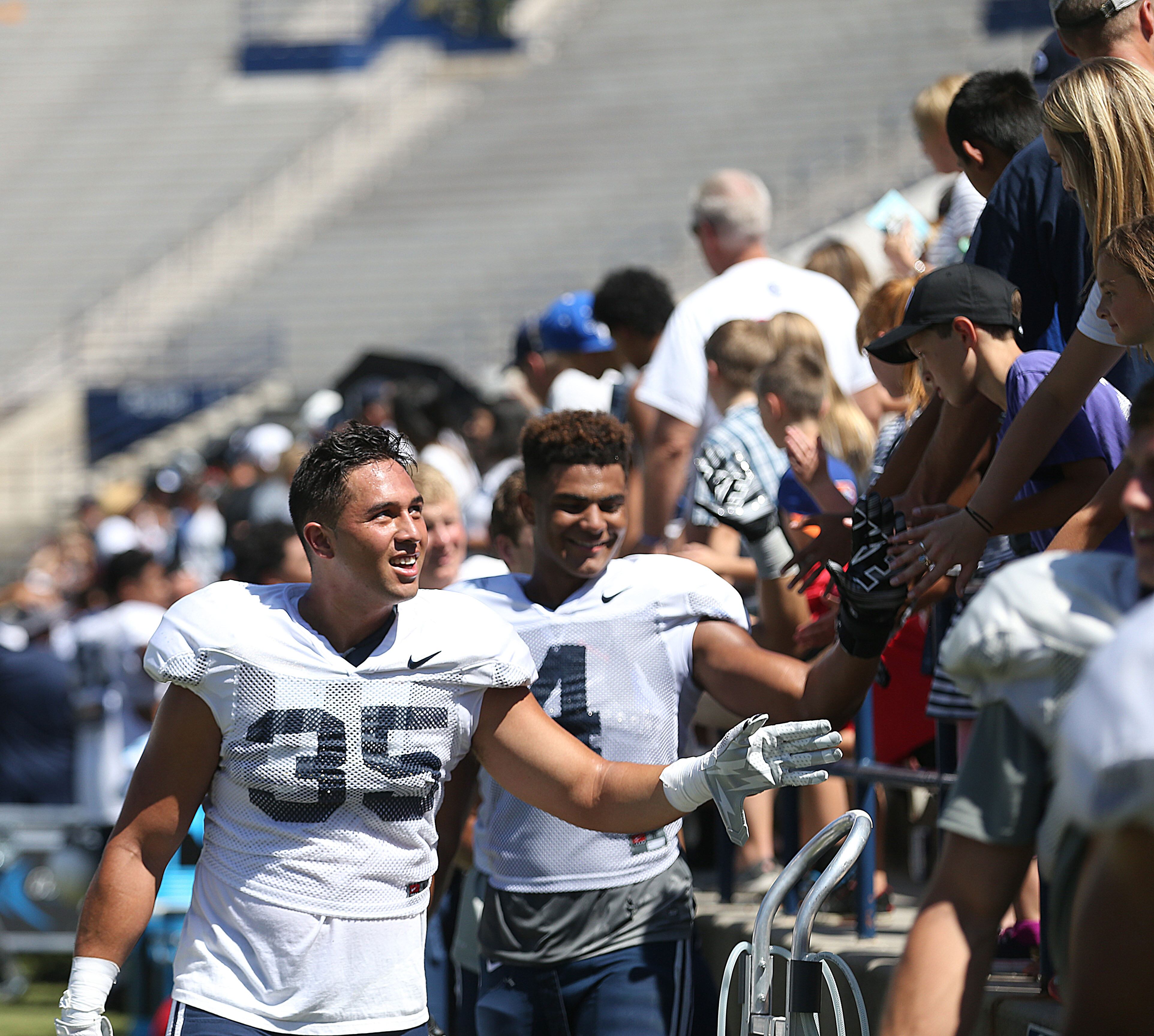 BYU's Va'a Niumatalolo, left, and Fred Warner greet fans after a scrimmage at BYU in Provo on Aug. 15, 2015. He learned from his father, “Coach Ken,” that there’s no need to compartmentalize one’s life.