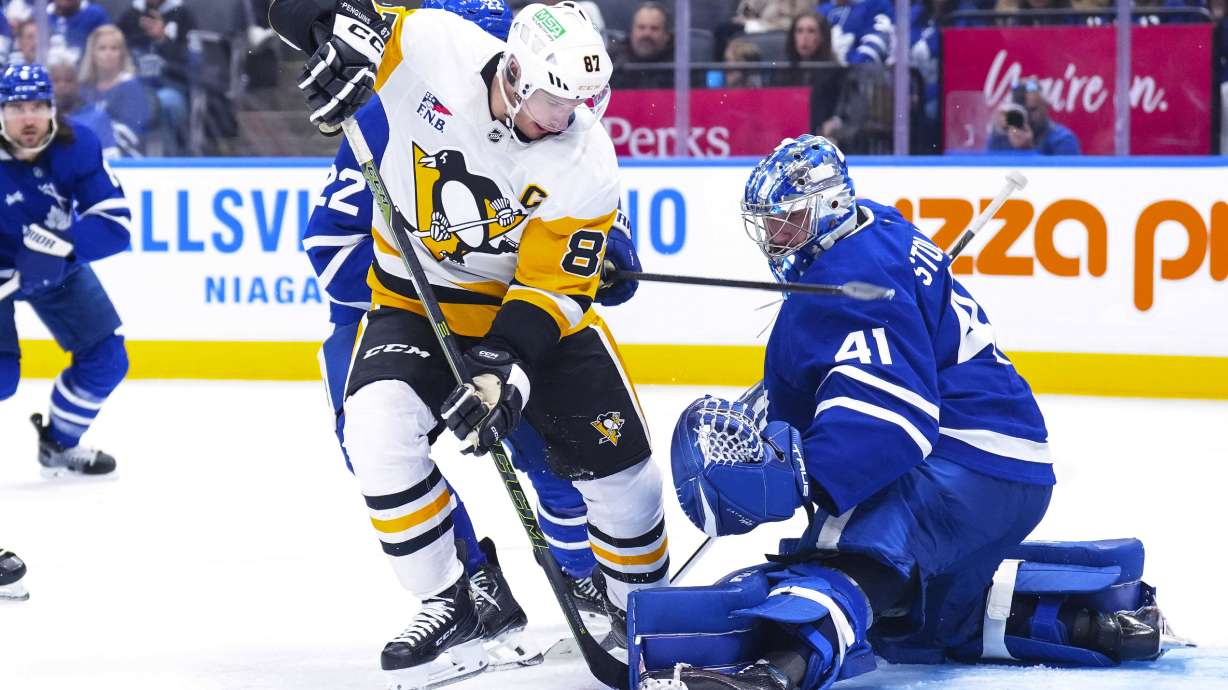 Toronto Maple Leafs goaltender Anthony Stolarz, right, saves a shot by Pittsburgh Penguins' Sidney Crosby (87) during third-period NHL hockey game action in Toronto, Saturday, Oct. 12, 2024.