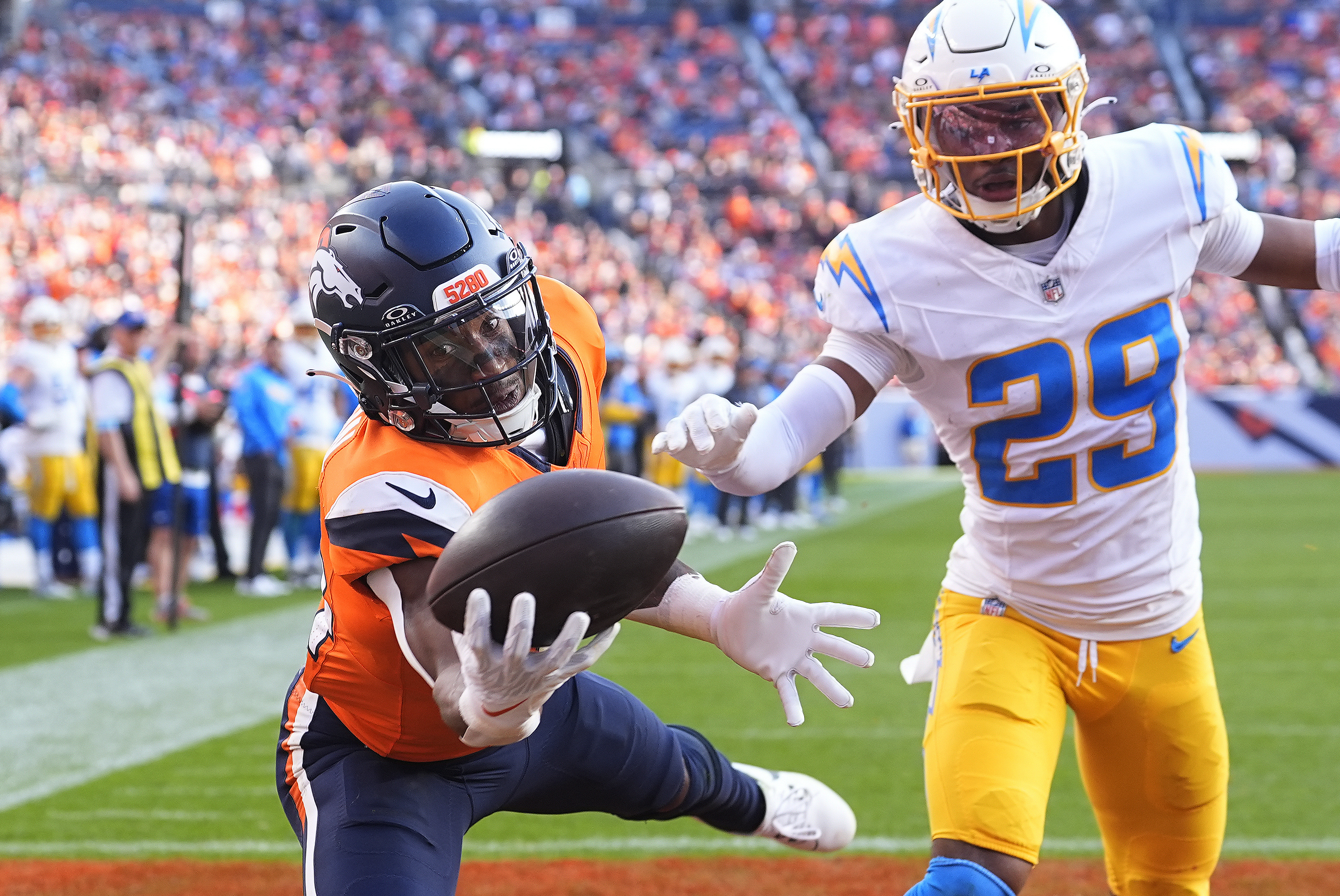 Denver Broncos wide receiver Courtland Sutton (14) catches a 15-yard touchdown pass against Los Angeles Chargers cornerback Tarheeb Still (29) during the second half of an NFL football game, Sunday, Oct. 13, 2024, in Denver.