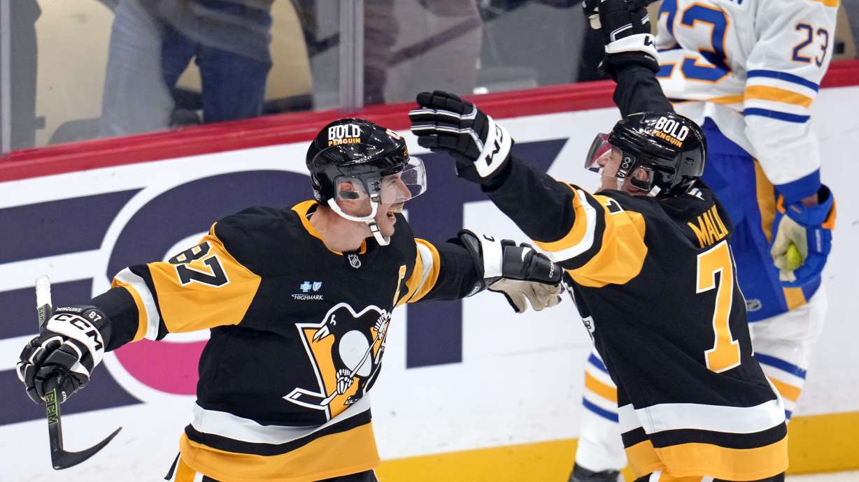 Pittsburgh Penguins' Sidney Crosby (87) celebrates his game-winning goal in overtime with Evgeni Malkin during an NHL hockey game against the Buffalo Sabres in Pittsburgh, Wednesday, Oct. 16, 2024.