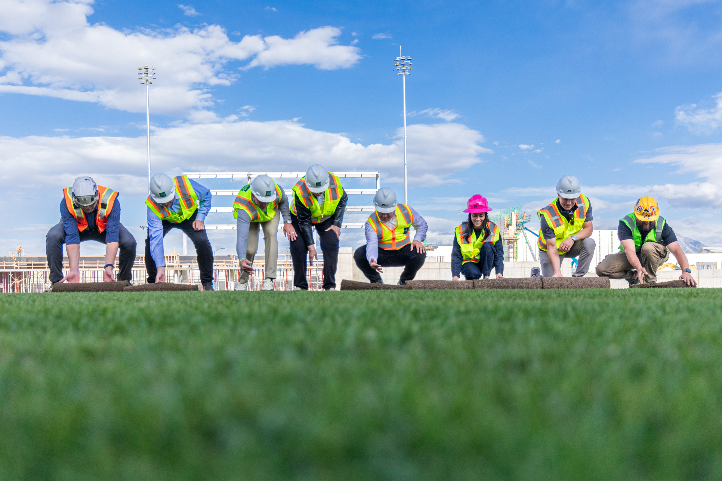 Representatives for the Larry H. Miller Company and Salt Lake Bees and other dignitaries roll the final patches of sod onto Daybreak Field Wednesday afternoon.