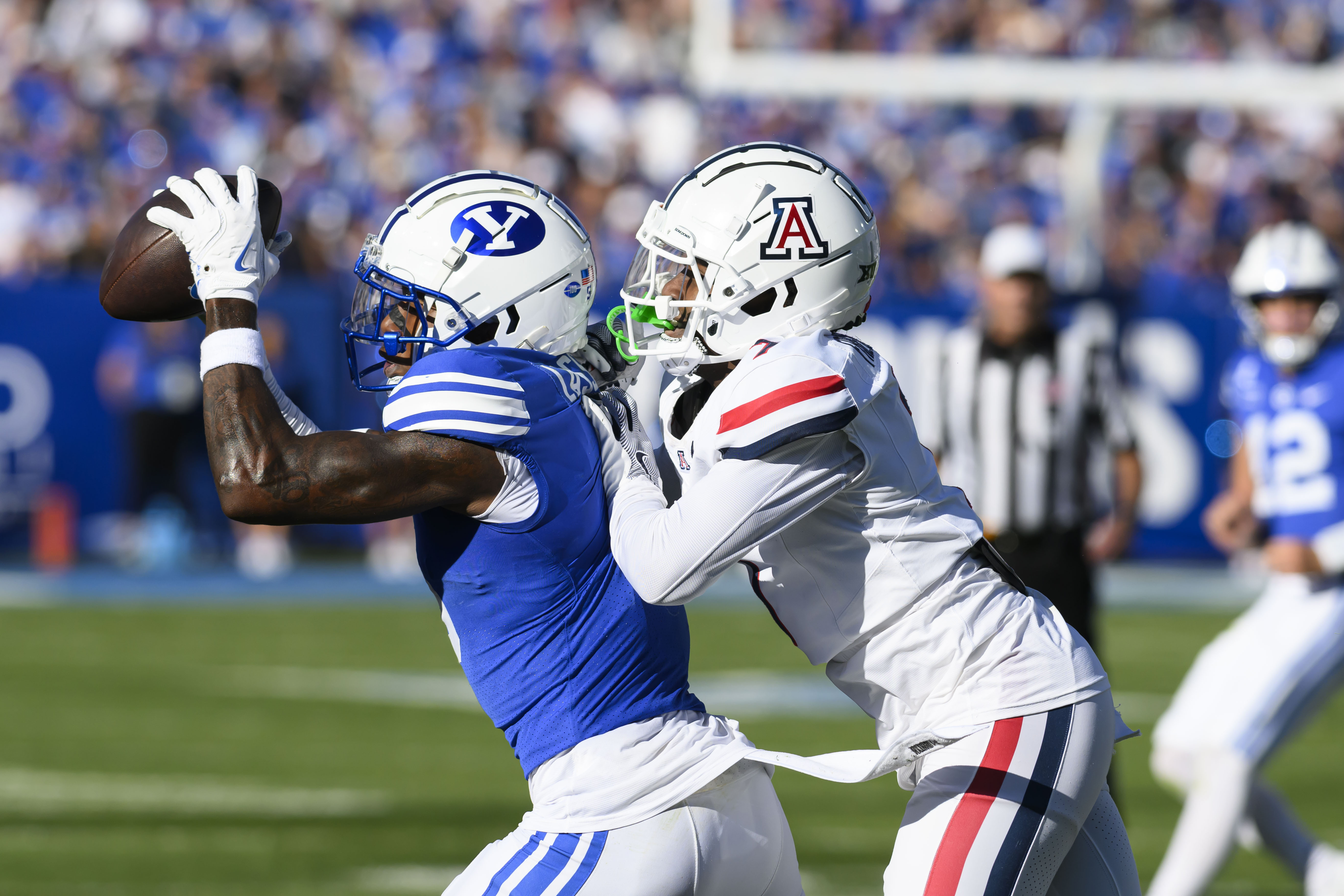 BYU wide receiver Darius Lassiter, left, makes a catch for a first down while defended by Arizona defensive back Demetrius Freeney, right, during an NCAA college football game Saturday, Oct. 12, 2024, in Provo, Utah. 