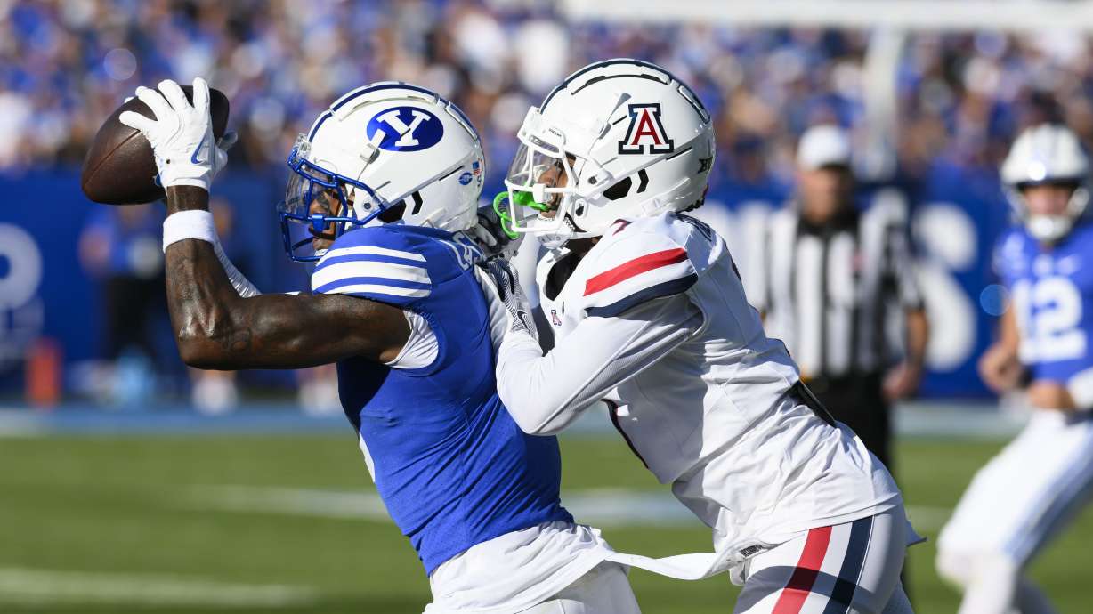 BYU wide receiver Darius Lassiter, left, makes a catch for a first down while defended by Arizona defensive back Demetrius Freeney, right, during an NCAA college football game Saturday, Oct. 12, 2024, in Provo, Utah.