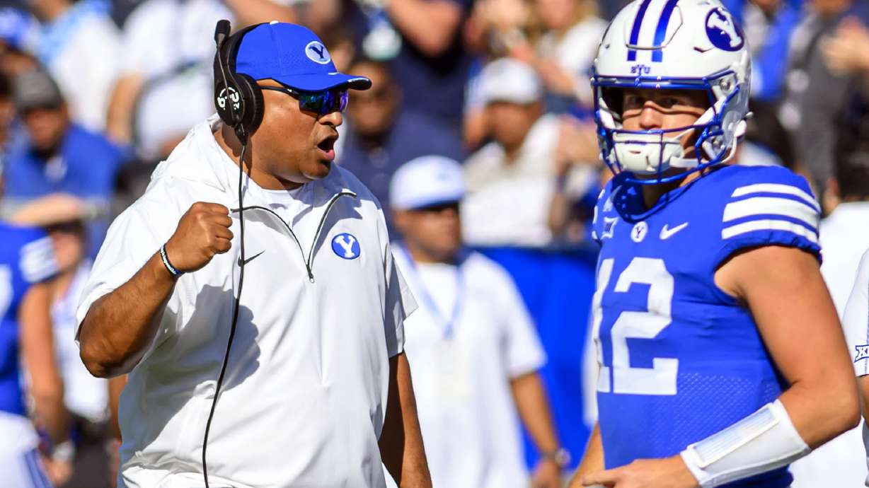 BYU head coach Kalani Sitake, left, celebrates an overturned play call after review during an NCAA college football game against Arizona, Saturday, Oct. 12, 2024, in Provo, Utah.