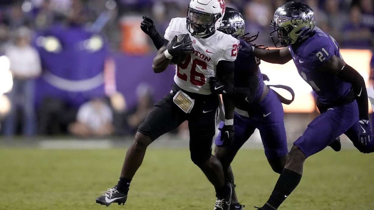 Houston running back Re'Shaun Sanford II (26) runs the ball as TCU safety Bud Clark (21) and others make the stop in the second half of an NCAA college football game Friday, Oct. 4, 2024, in Fort Worth, Texas.