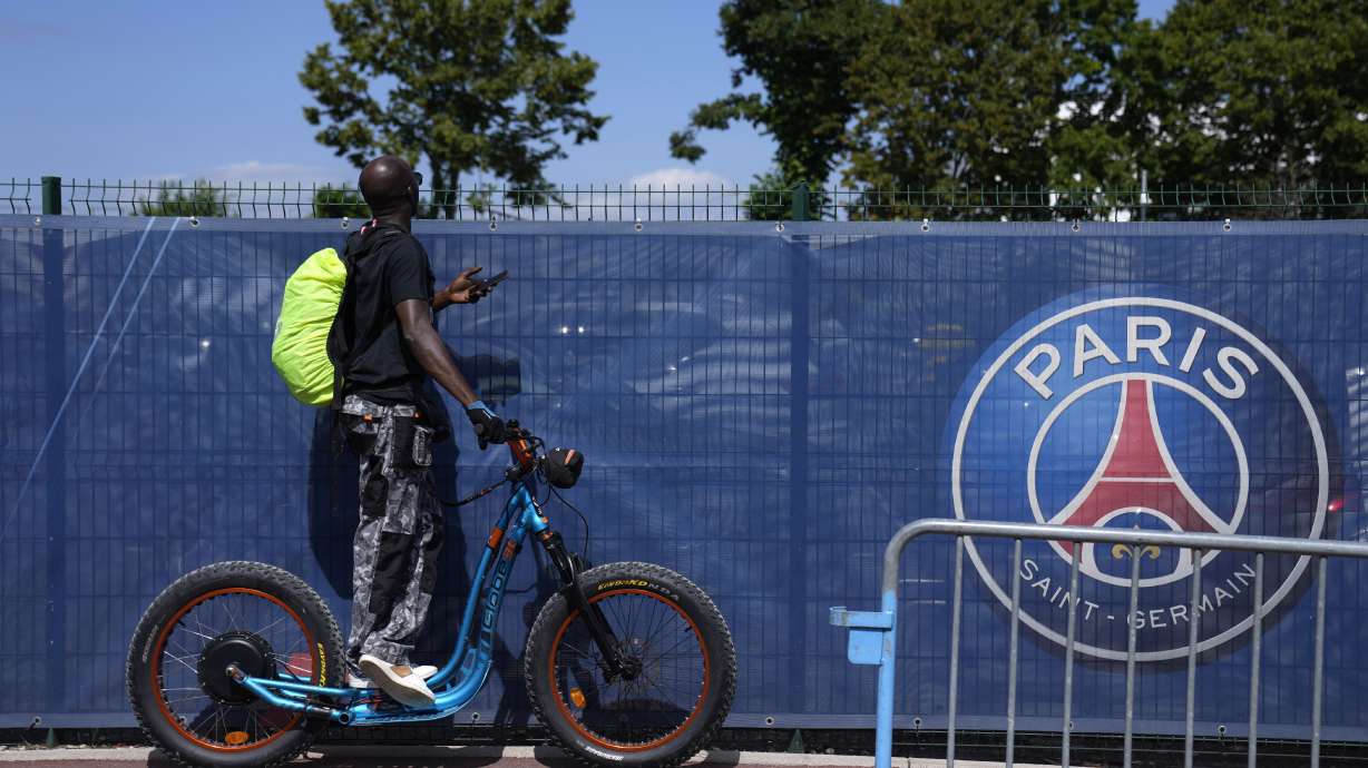 FILE - A soccer fan tries to watch the PSG soccer team training at the Paris Saint-Germain training camp in Saint-Germain-en-Laye, west of Paris, Friday, Aug. 13, 2021.