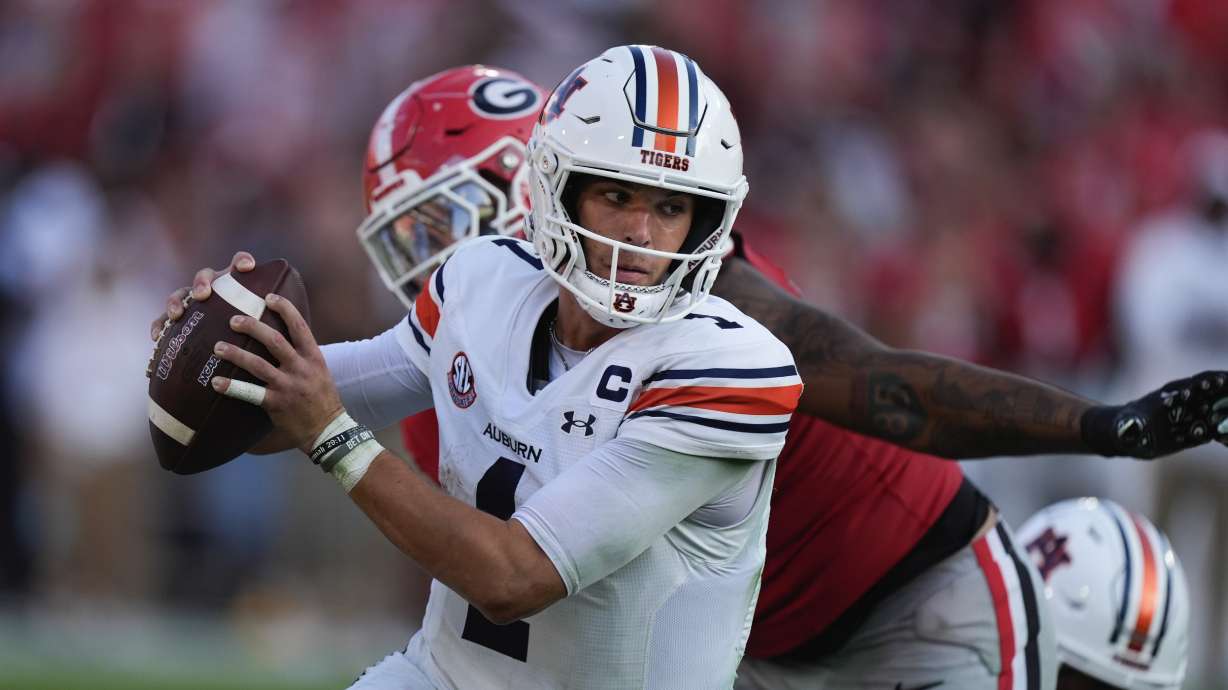 Auburn quarterback Payton Thorne (1) tries to elude a Georgia defender in the second half of an NCAA college football game Saturday, Oct. 5, 2024, in Athens, Ga.