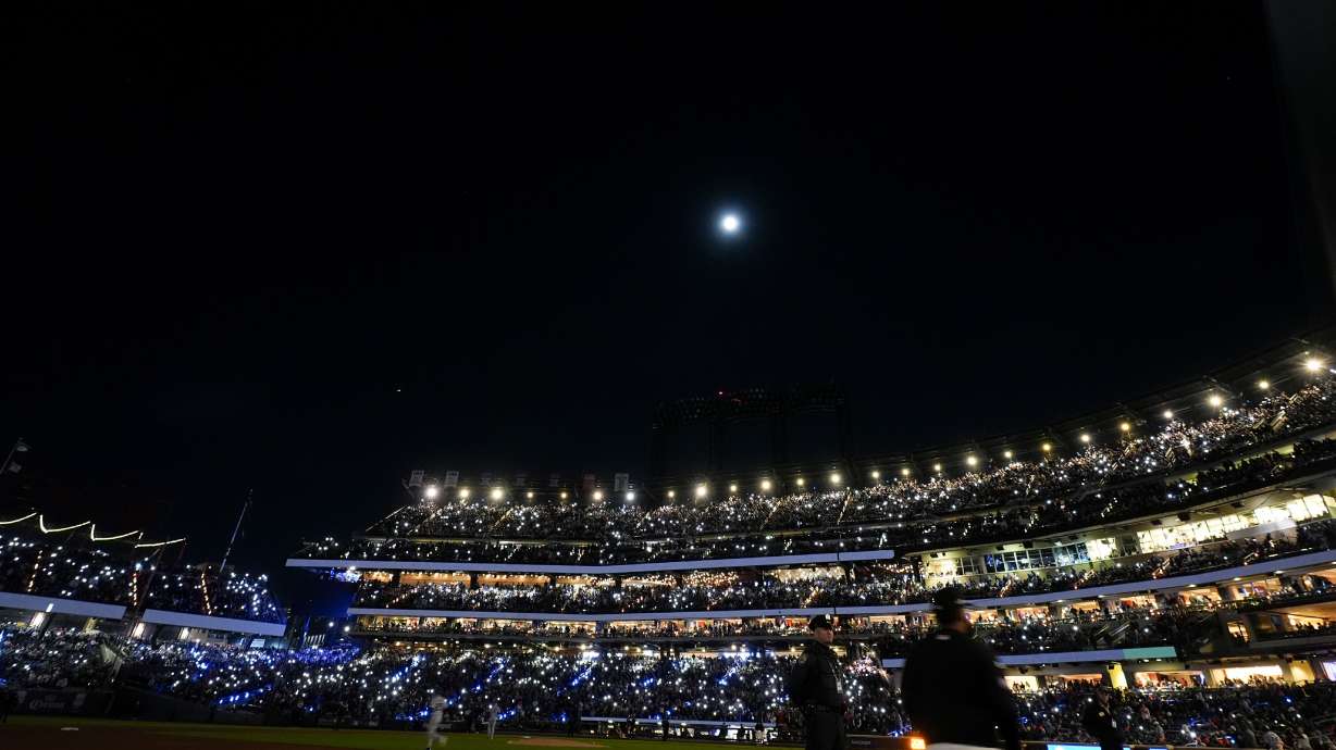Fans light up the stadium during the third inning in Game 3 of a baseball NL Championship Series between the Los Angeles Dodgers and the New York Mets, Wednesday, Oct. 16, 2024, in New York.