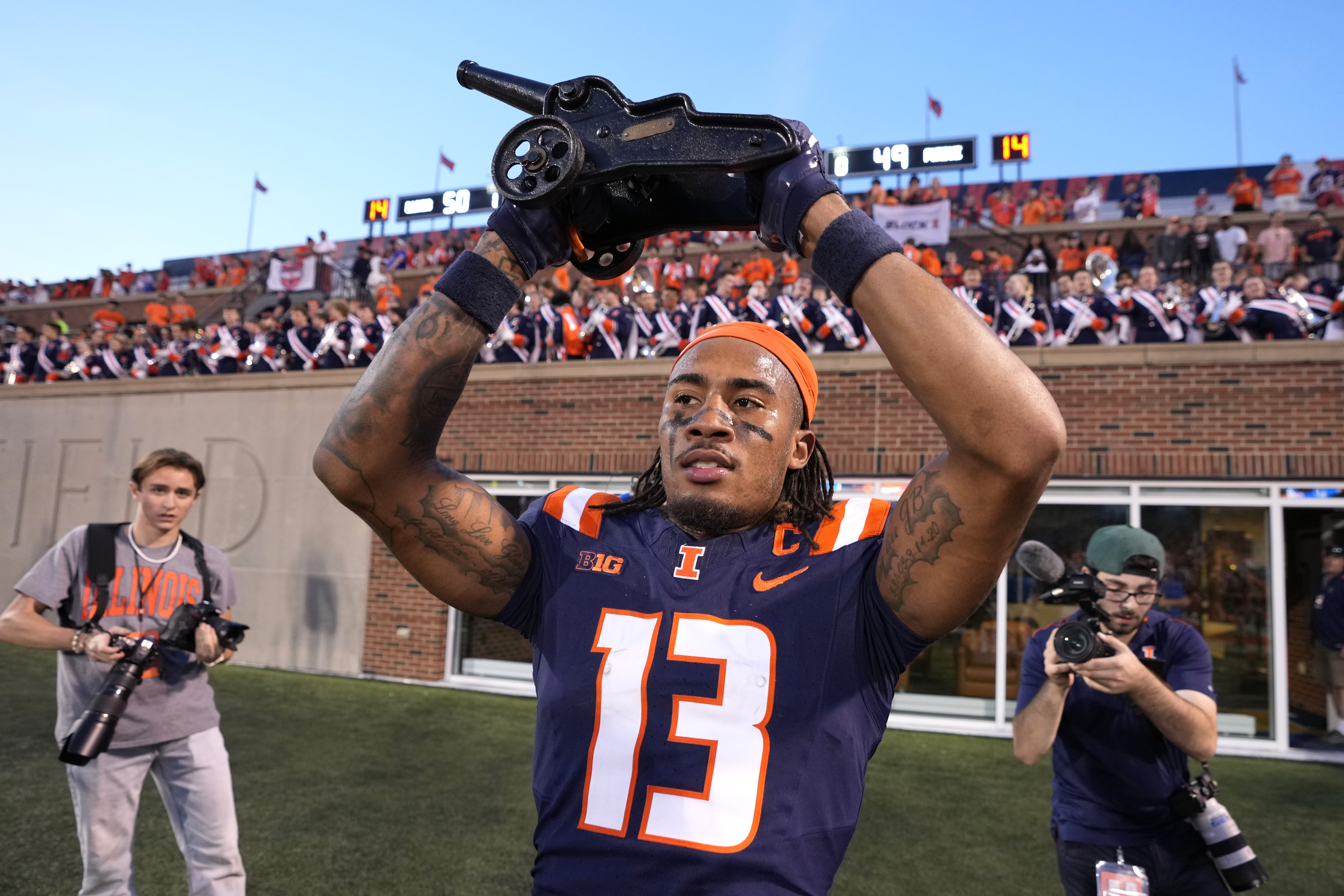 Illinois wide receiver Pat Bryant celebrates with the Purdue cannon after the team's 50-49 overtime win over Purdue in an NCAA college football game Saturday, Oct. 12, 2024, in Champaign, Ill.