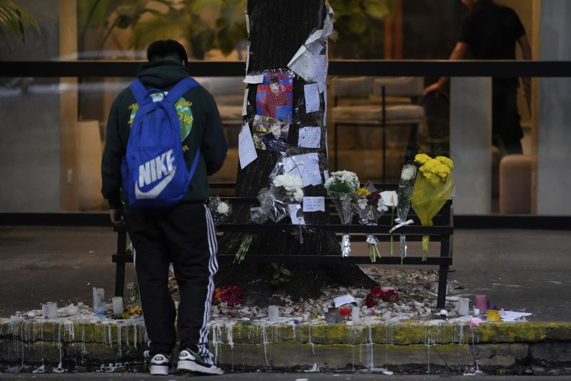 A fan stands in front of a makeshift memorial outside the hotel where former One Direction singer Liam Payne was found dead after falling from a balcony in Buenos Aires, Argentina, the morning after his death, Thursday.