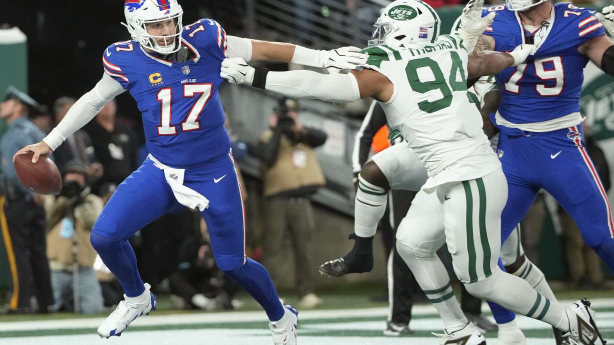 Buffalo Bills quarterback Josh Allen (17) scrambles away from New York Jets defensive end Solomon Thomas (94) during the first half of an NFL football game in East Rutherford, N.J., Monday, Oct. 14, 2024.