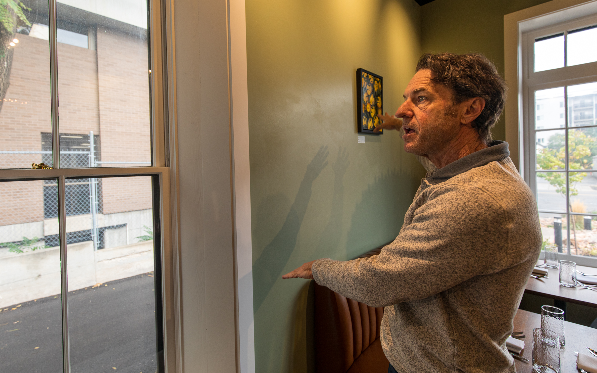 Jeff Taylor, owner of the Midgley House, explains the process that went into restoring the historic building's windows during a tour of the building on Thursday.