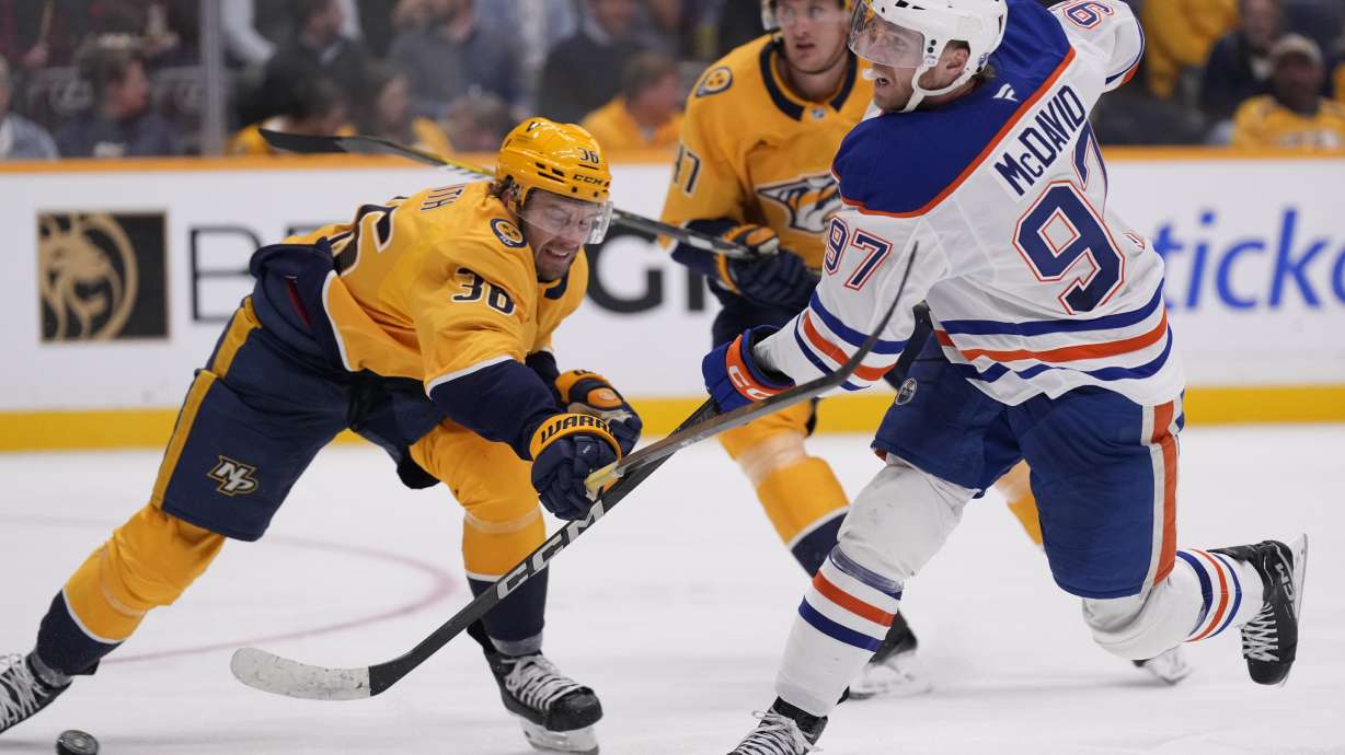 Edmonton Oilers center Connor McDavid (97) shoots the puck past Nashville Predators left wing Cole Smith (36) during the third period of an NHL hockey game Thursday, Oct. 17, 2024, in Nashville, Tenn.