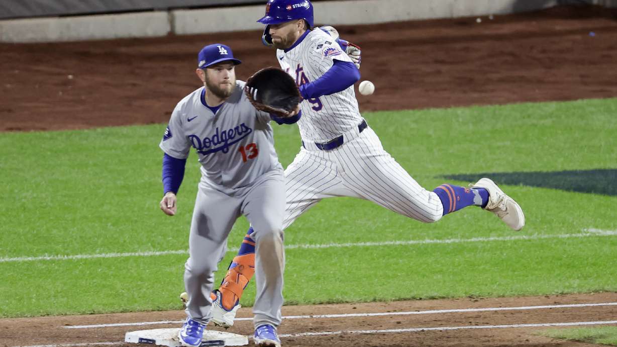 New York Mets' Brandon Nimmo is safe at first past Los Angeles Dodgers first baseman Max Muncy during the third inning in Game 4 of a baseball NL Championship Series, Thursday, Oct. 17, 2024, in New York.