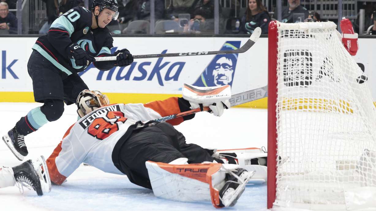 Seattle Kraken right wing Eeli Tolvanen (20) scores past diving Philadelphia Flyers goaltender Ivan Fedotov (82) during the second period of an NHL hockey game Thursday, Oct. 17, 2024, in Seattle.