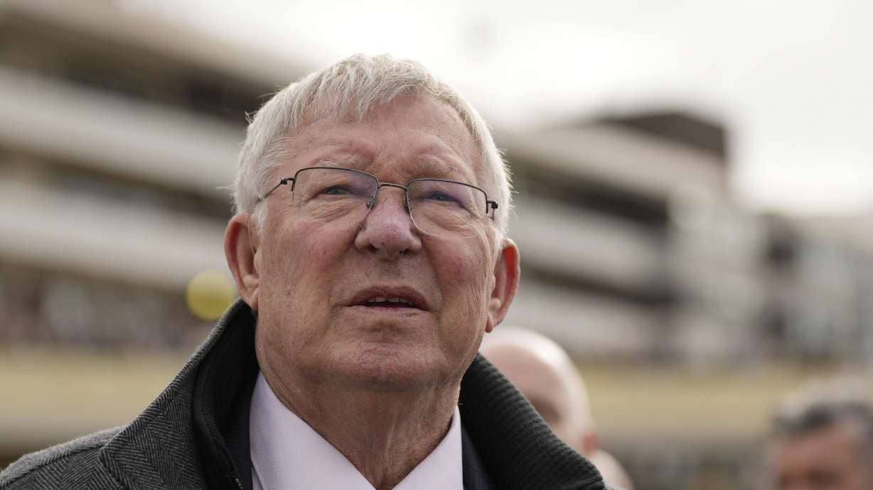 FILE - Former Manchester United manager Alex Ferguson, watches a large TV screen during The County Hurdle race, during the final day of the Cheltenham Festival at Cheltenham Racecourse, England, Friday, March 15, 2024.