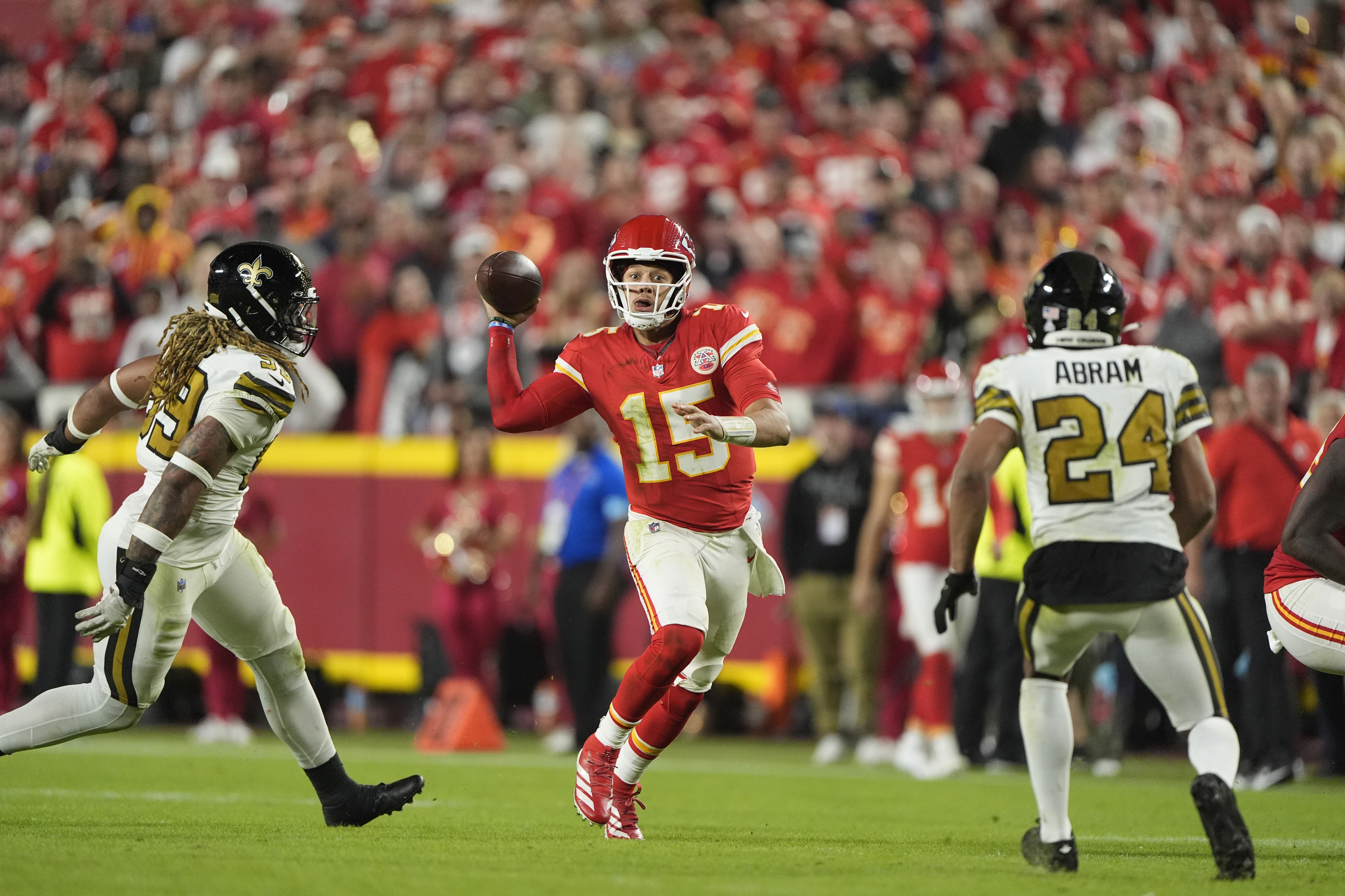 Kansas City Chiefs quarterback Patrick Mahomes, center, runs with the ball as New Orleans Saints defensive end Chase Young and safety Johnathan Abram (24) defend during the second half of an NFL football game Monday, Oct. 7, 2024, in Kansas City, Mo. 