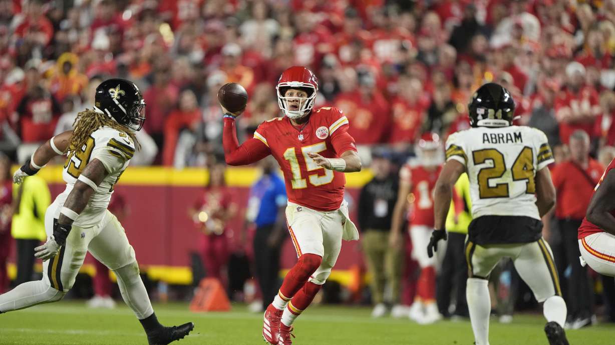 Kansas City Chiefs quarterback Patrick Mahomes, center, runs with the ball as New Orleans Saints defensive end Chase Young and safety Johnathan Abram (24) defend during the second half of an NFL football game Monday, Oct. 7, 2024, in Kansas City, Mo.