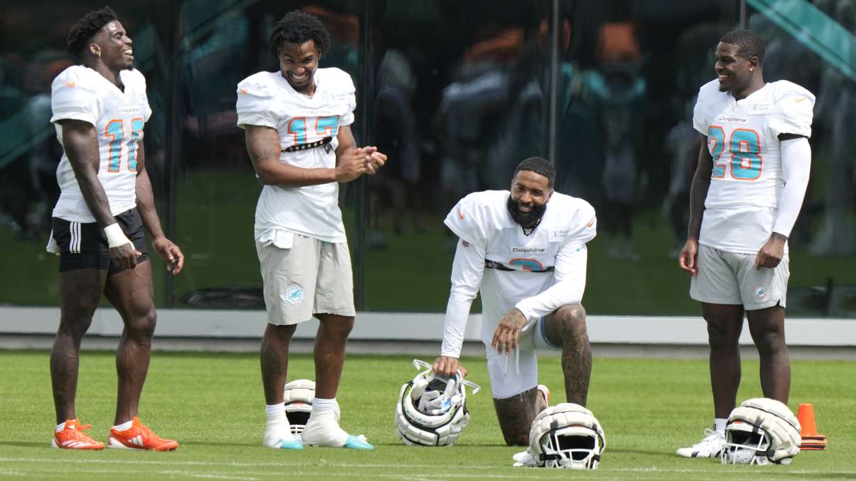 Miami Dolphins wide receiver Odell Beckham Jr., second from right, talks with wide receiver Tyreek Hill (10), wide receiver Jaylen Waddle (17) and running back De'Von Achane (28) during practice at the NFL football team's training facility, Thursday, Oct. 3, 2024, in Miami Gardens, Fla.