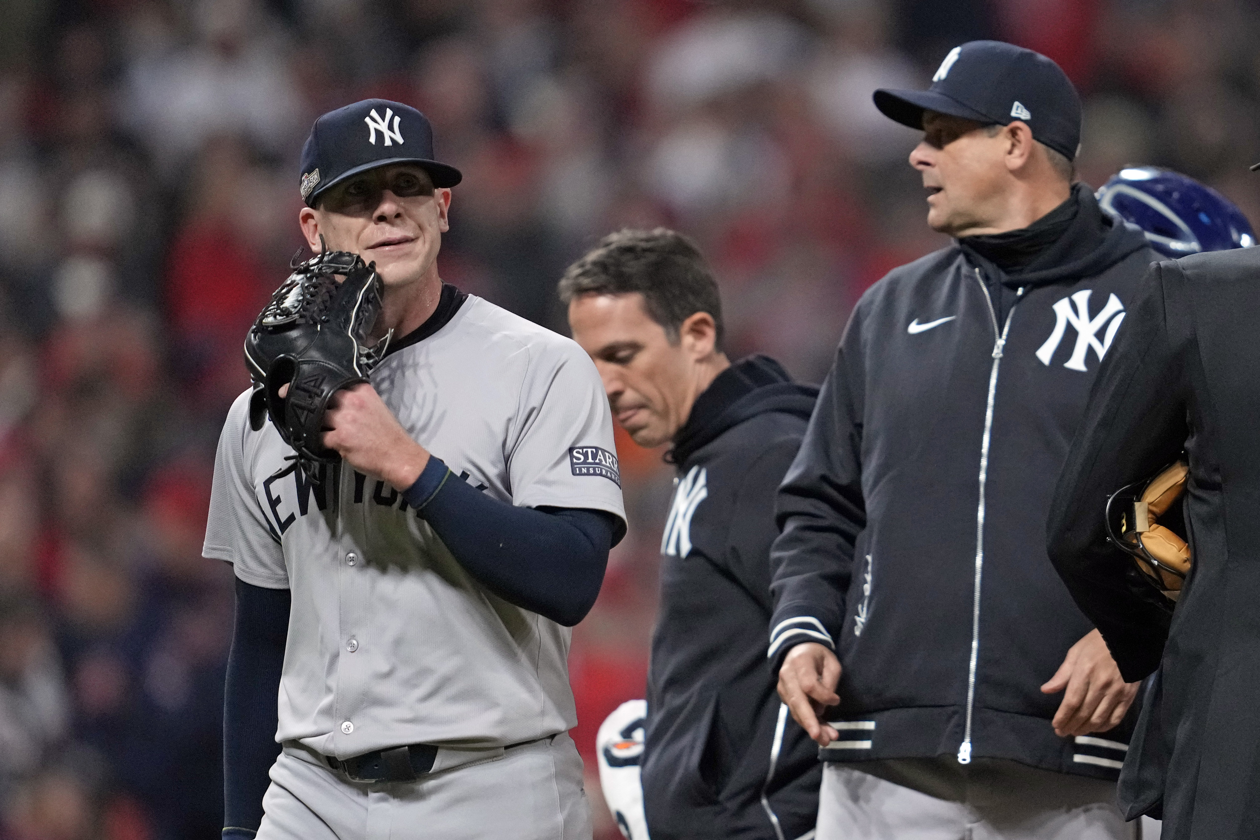 New York Yankees relief pitcher Ian Hamilton, left, leaves the game during the sixth inning in Game 3 of the baseball AL Championship Series against the Cleveland GuardiansvThursday, Oct. 17, 2024, in Cleveland.