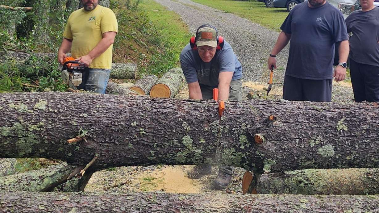 Latter-day Saint volunteers assist in the cleanup following Hurricane Helene. From left to right: David Lezette, Ted Brothers, Karl Blanton, and Sebastian Williams cut through downed trees to clear roadways in Hickory, North Carolina, on Sept. 28.
