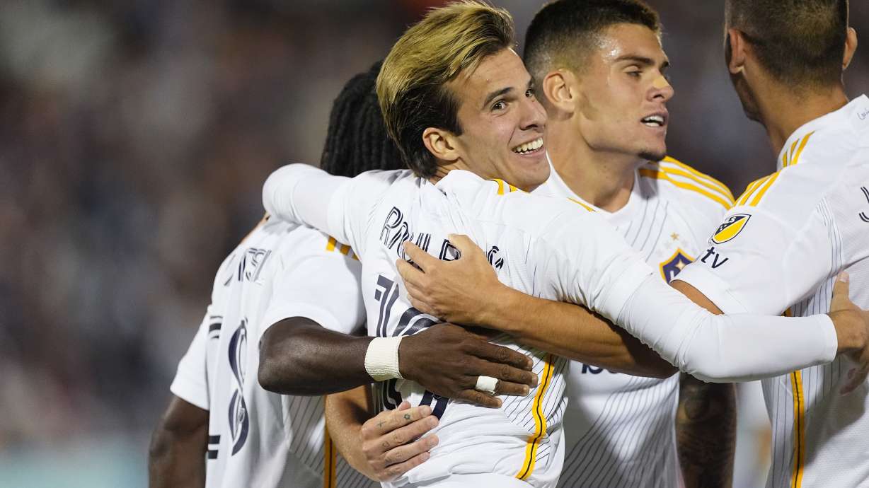 Los Angeles Galaxy midfielder Riqui Puig, front, celebrates with teammates after scoring a goal against the Colorado Rapids in the second half of an MLS soccer match Wednesday, Oct. 2, 2024, in Commerce City, Colo.