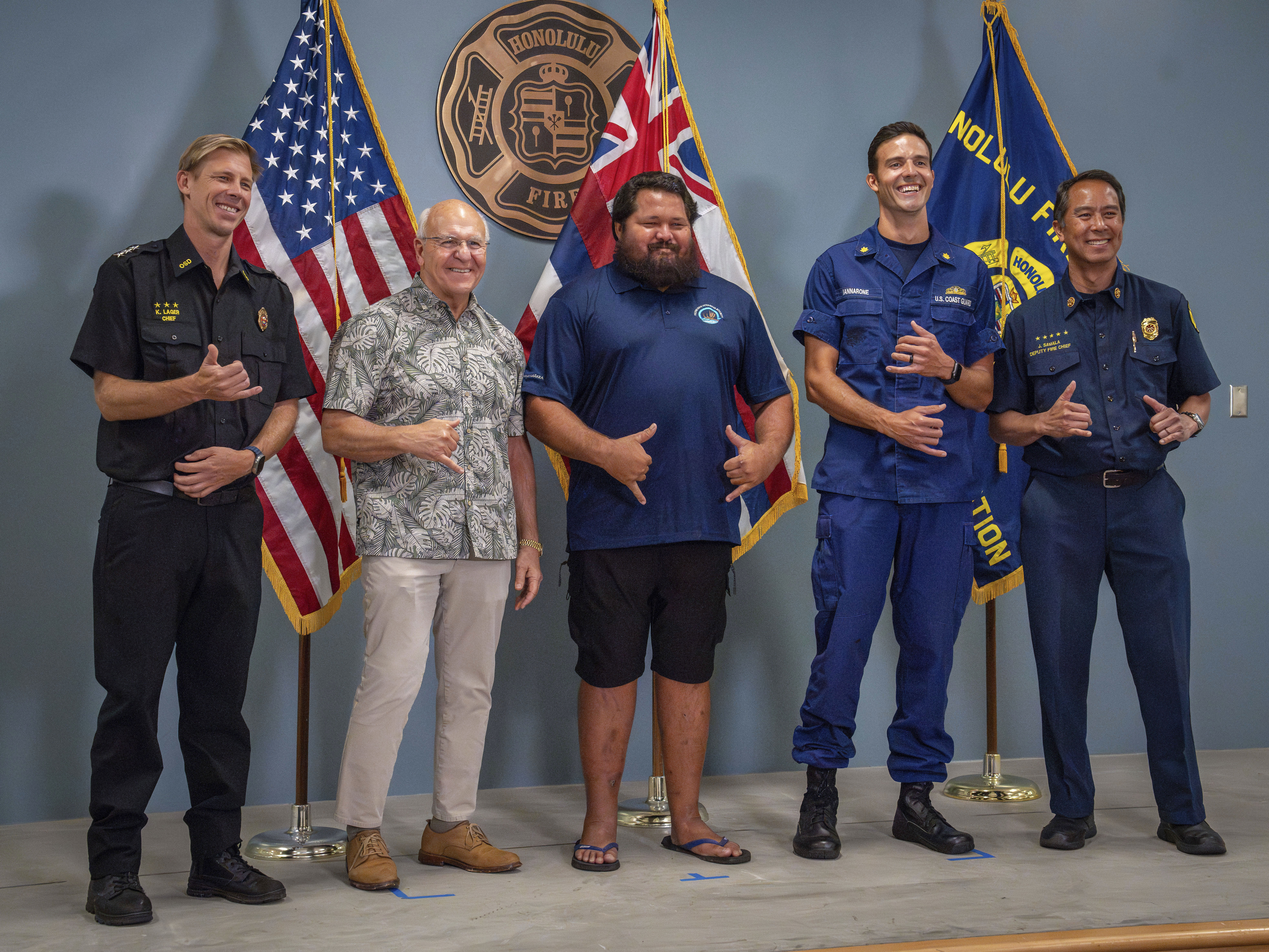 From left, Acting Director of Honolulu Ocean Safety Kurt Lager, Honolulu Mayor Rick Blangiardi, lifeguard Noland Keaulana, Coast Guard Lt. Cmdr. Nicholas Iannarone and Honolulu Deputy Fire Chief Jason Samala make shaka gestures as they stand for a photo at a news conference for a rescue of a 17-year-old kayaker in Honolulu on Thursday, Oct. 17, 2024. 