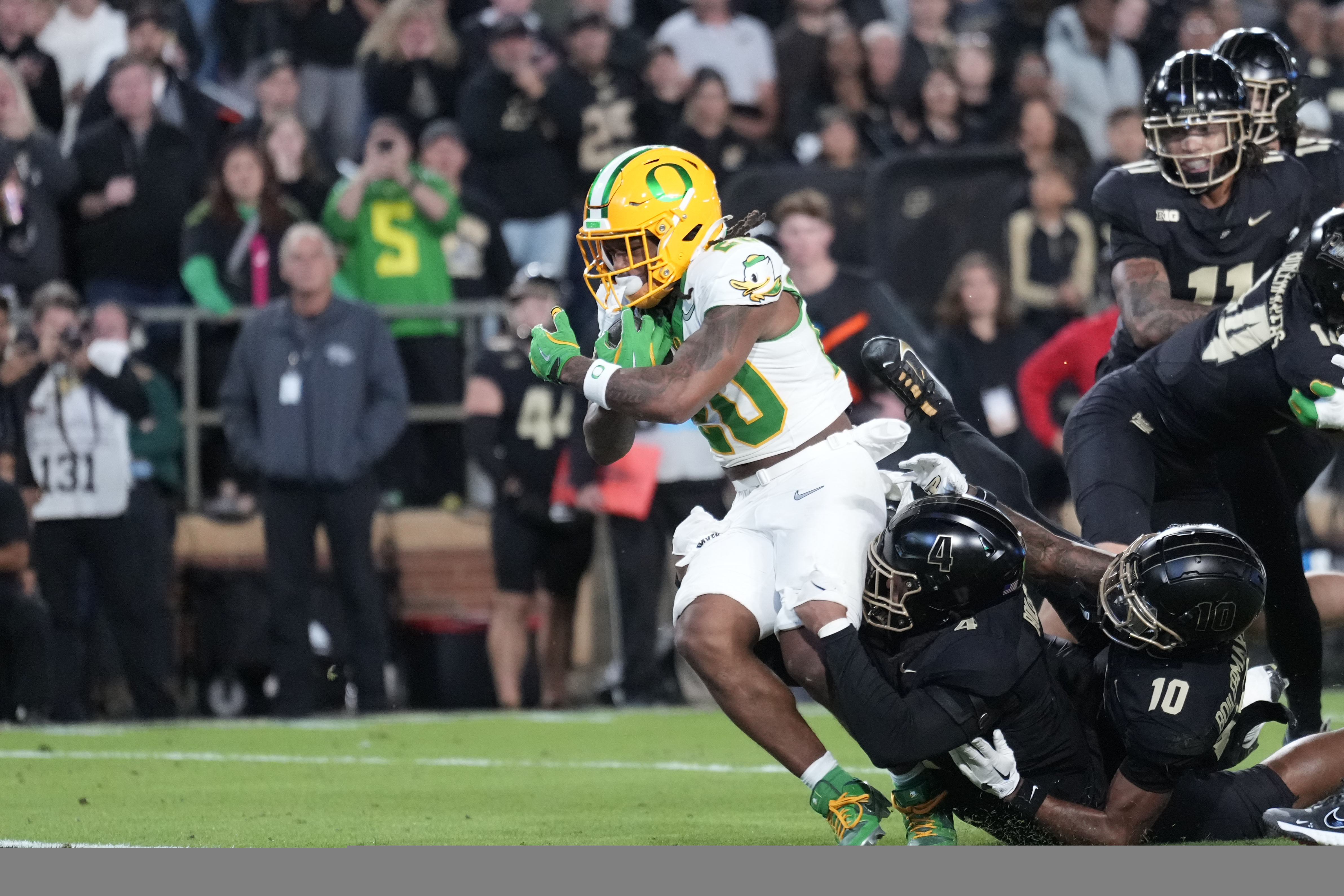 Oregon running back Jordan James (20) scores a touchdown while being tackled by Purdue linebacker Kydran Jenkins (4) in the first half of an NCAA college football game in West Lafayette, Ind., Friday, Oct. 18, 2024. 