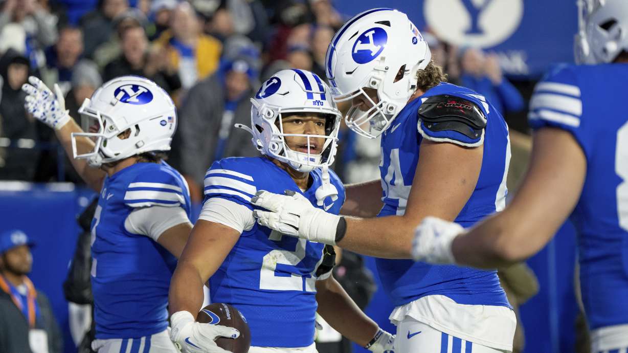 BYU running back LJ Martin, second from left, celebrates after scoring a touchdown in the second half of an NCAA college football game against Oklahoma State, Friday, Oct. 18, 2024, in Provo, Utah.