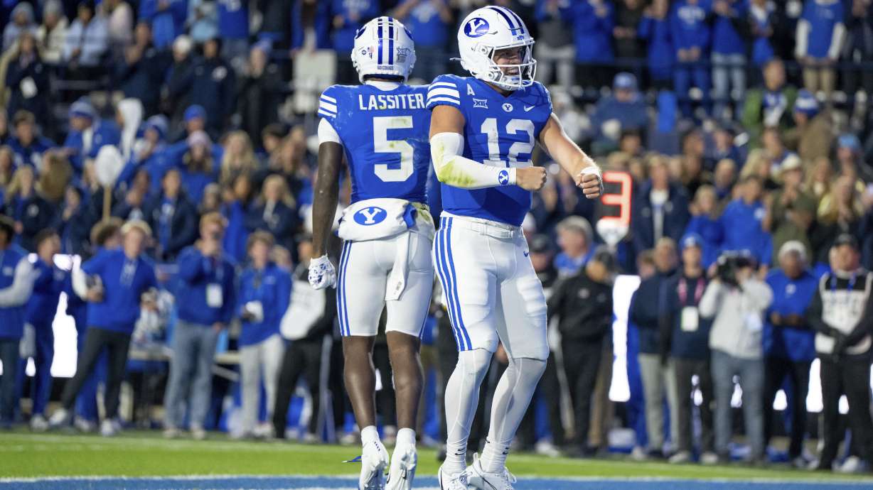 BYU wide receiver Darius Lassiter (5) and quarterback Jake Retzlaff (12) celebrate after Retzlaff ran for a touchdown in the first half of an NCAA college football game against Oklahoma State, Friday, Oct. 18, 2024, in Provo, Utah.