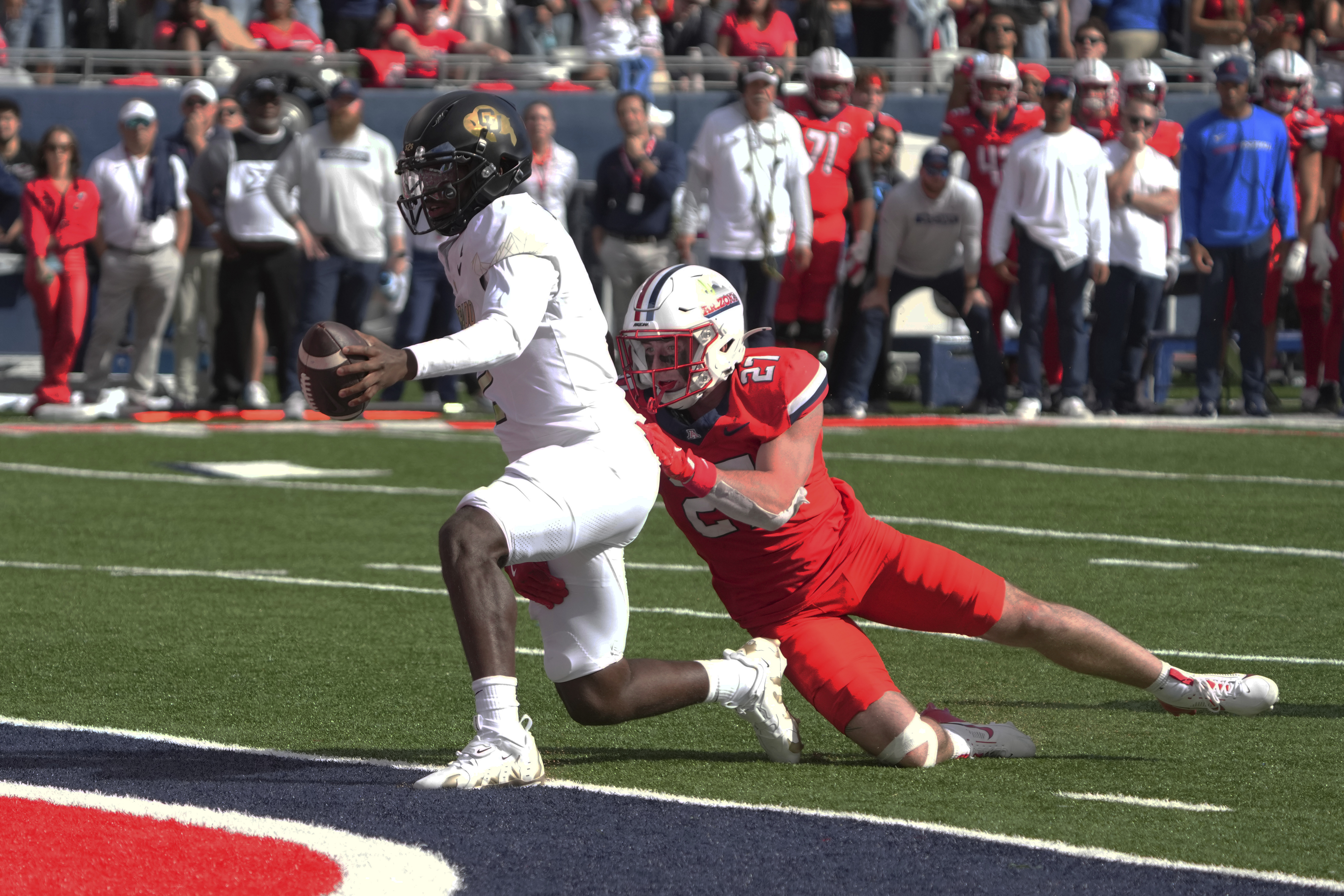 Colorado quarterback Shedeur Sanders scores a touchdown as Arizona defensive back Owen Goss (27) tries to make the tackle in the first half during an NCAA college football game, Saturday, Oct. 19, 2024, in Tucson, Ariz.