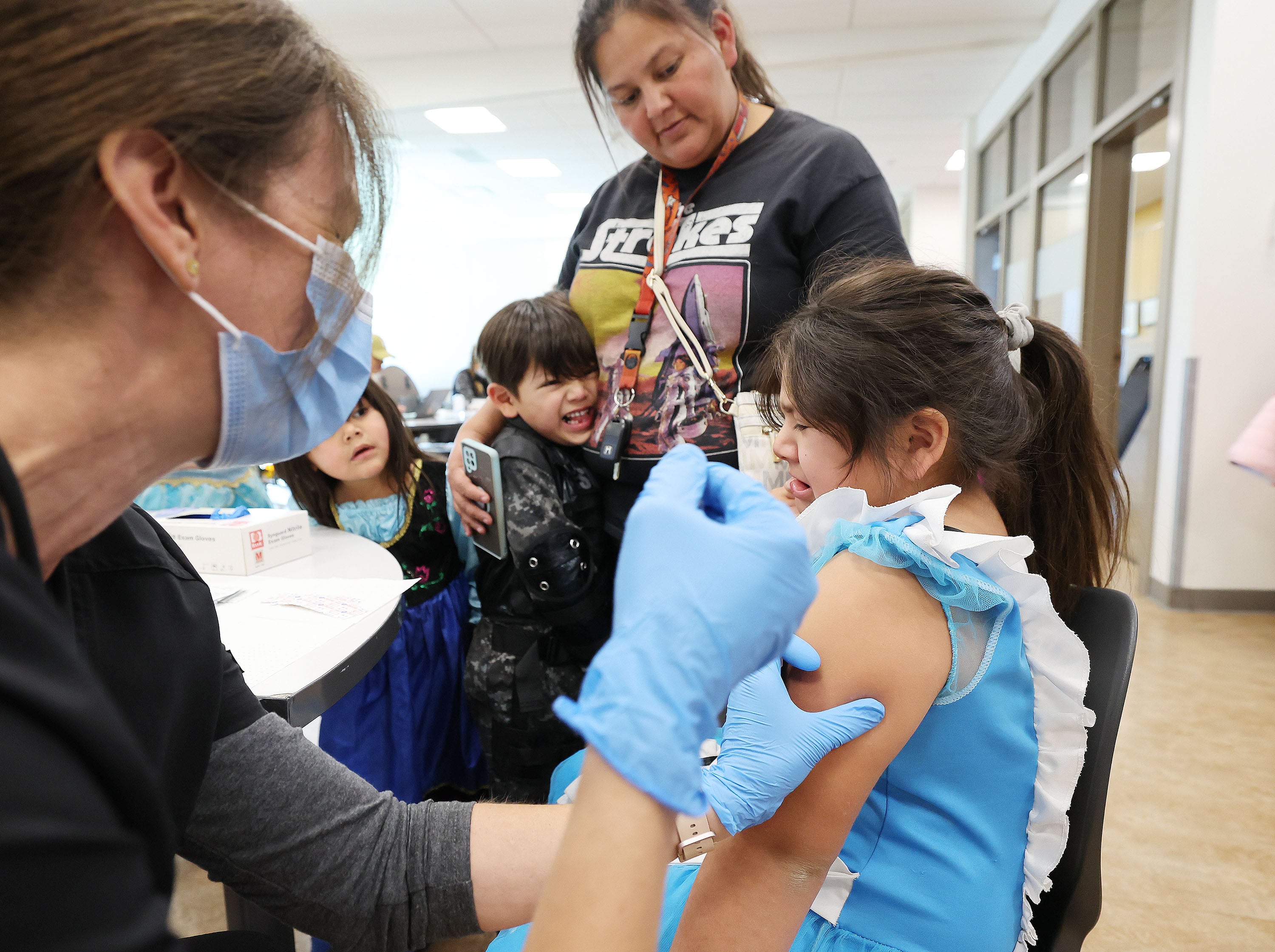 Sara Avalos watches her daughter Kiara Avalos, 7, get her COVID-19 vaccine at the Community Health Center Neighborhood Clinic in Salt Lake City on Oct. 28, 2022.