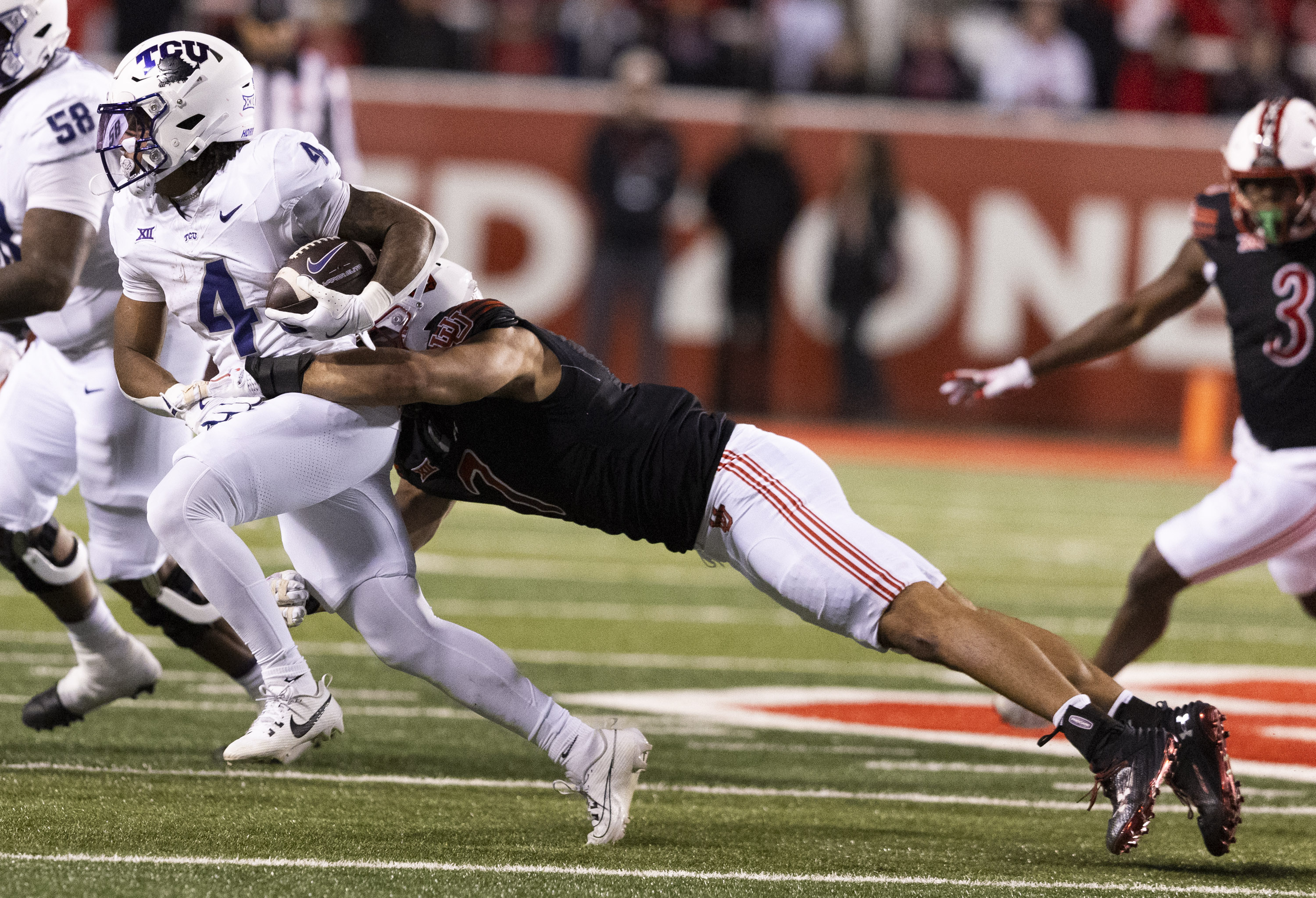 Utah Utes defensive end Van Fillinger (7) tackles TCU Horned Frogs running back Cam Cook (4) during a game at Rice-Eccles Stadium in Salt Lake City on Saturday, Oct. 19, 2024.