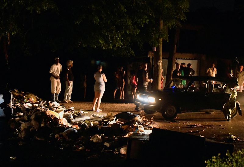 People stand on a blocked street during a protest against a blackout, as Cuba's government said on Saturday that it had made some progress in gradually reestablishing electrical service across the island, in Havana, Cuba. 