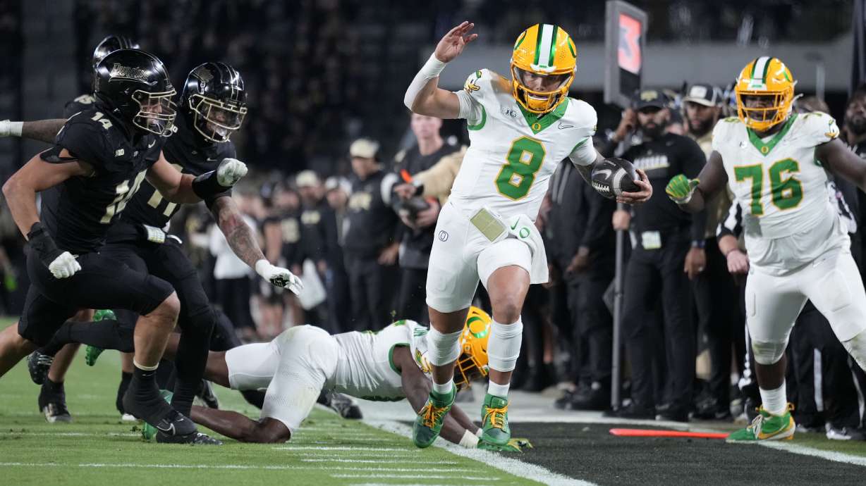 Oregon quarterback Dillon Gabriel (8) tries to stay inbounds while running up the sideline during the second half of an NCAA college football game against Purdue in West Lafayette, Ind., Friday, Oct. 18, 2024.