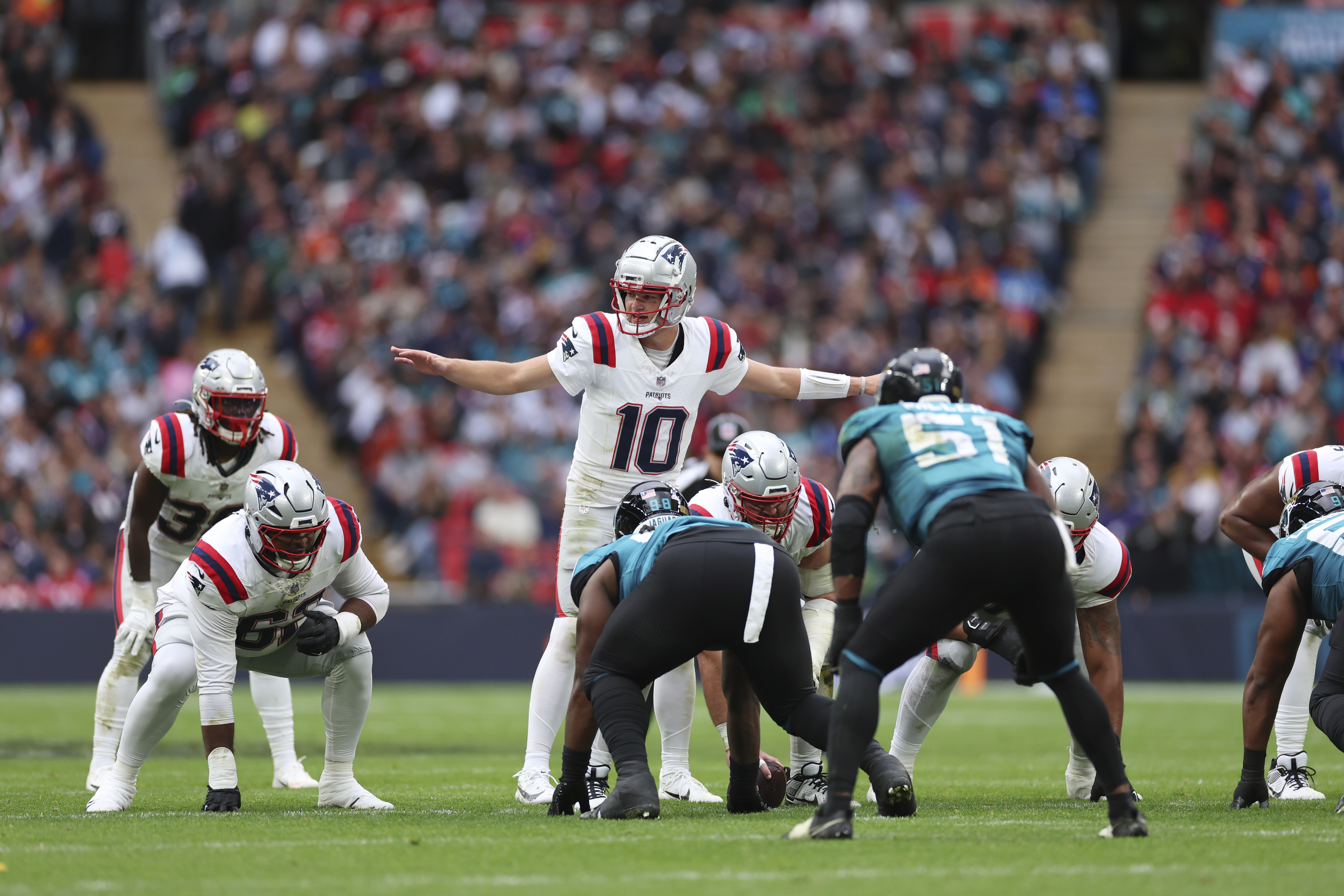 New England Patriots quarterback Drake Maye (10) calls an audible during the first half of an NFL football game against the Jacksonville Jaguars, Sunday, Oct. 20, 2024, in London. 