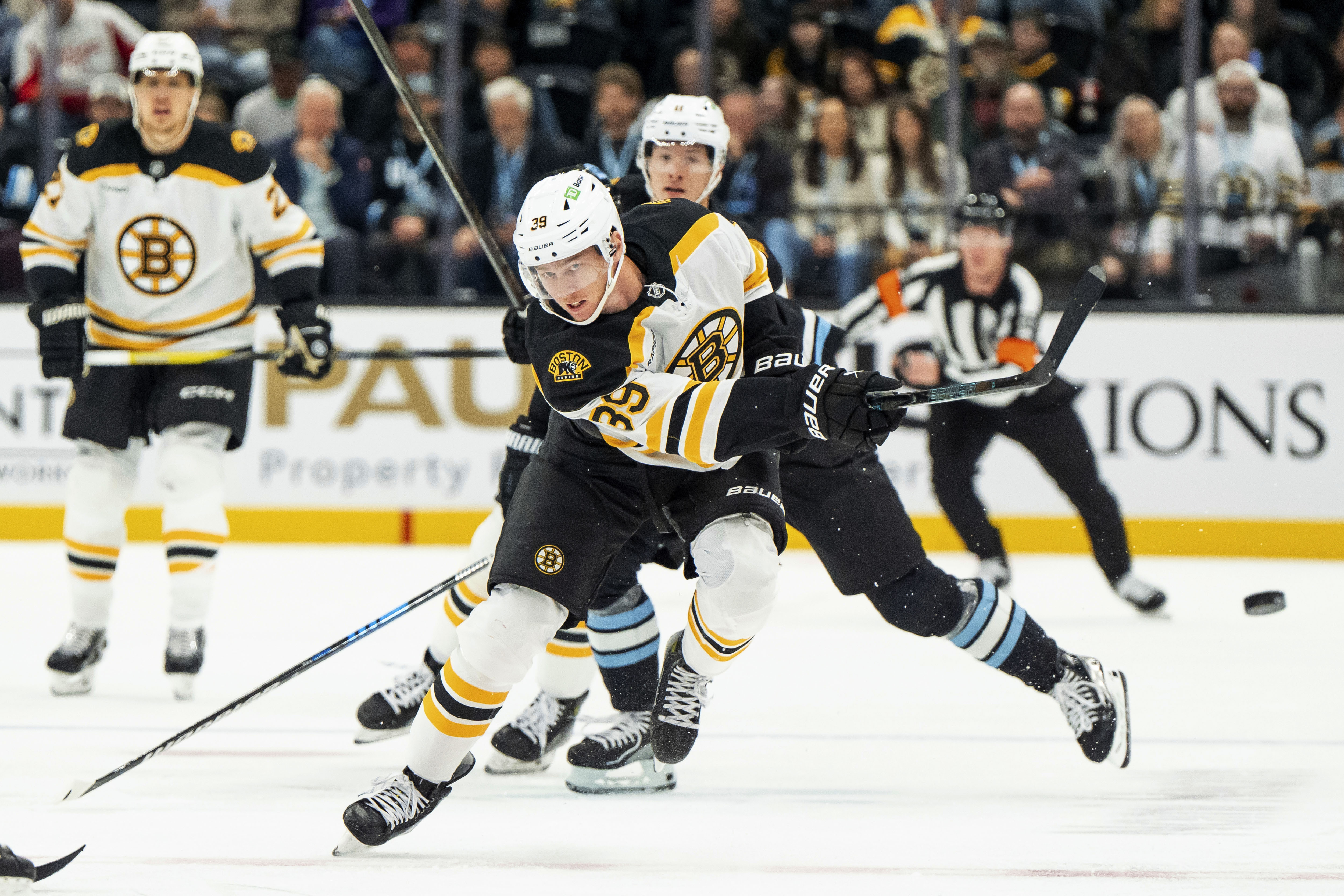 Boston Bruins center Morgan Geekie moves the puck up the ice during the first period of an NHL hockey game against the Utah Hockey Club, Saturday, Oct. 19, 2024, in Salt Lake City. 