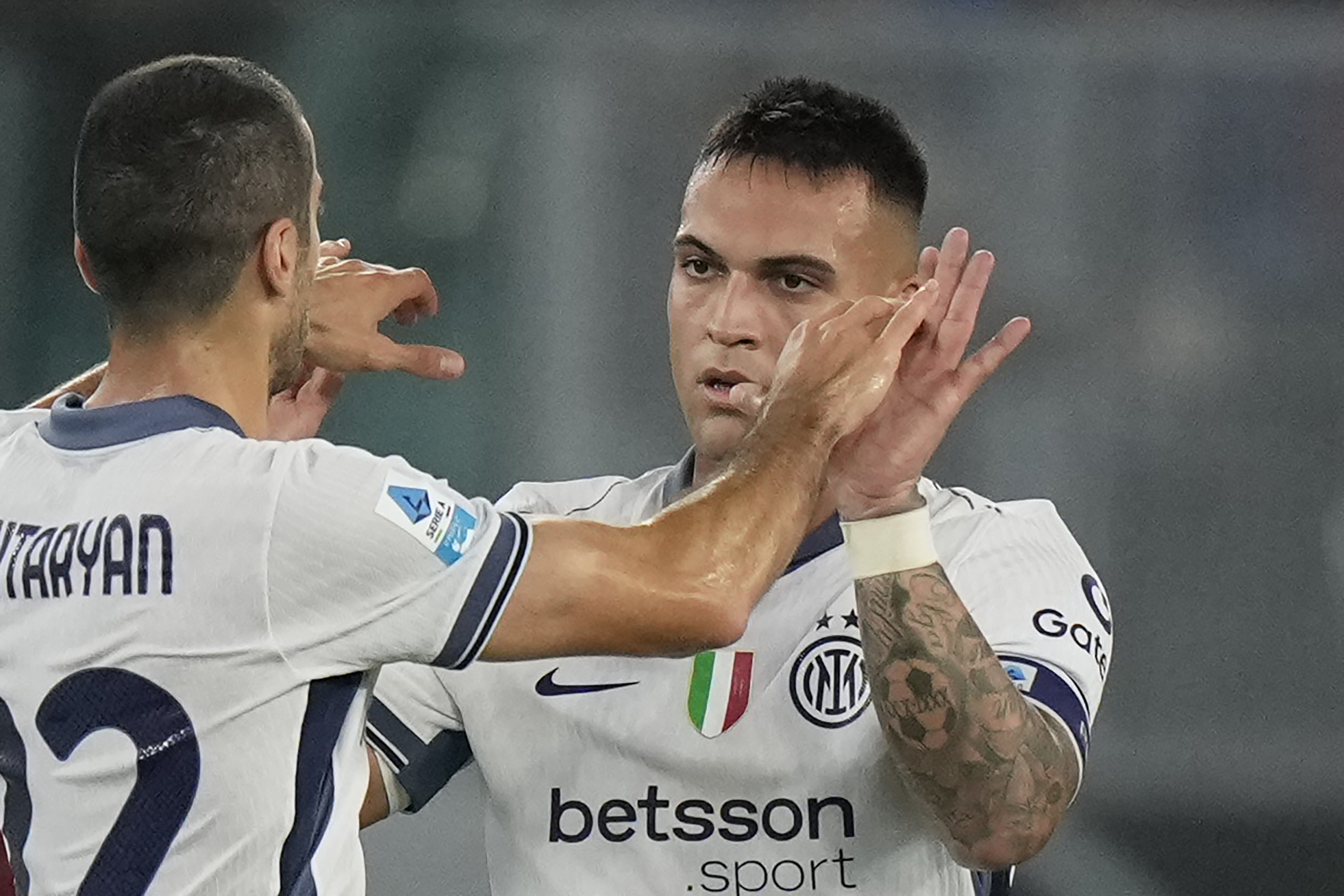 Inter Milan's Lautaro Martinez, right, celebrates after scoring the opening goal with Inter Milan's Henrikh Mkhitaryan during the Serie A soccer match between Roma and Inter Milan at the Stadio Olimpico in Rome, Italy, Sunday, Oct. 20, 2024.