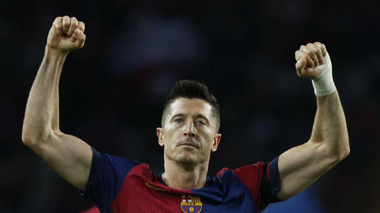 Barcelona's Robert Lewandowski celebrates after scoring the opening goal from the penalty spot during a Spanish La Liga soccer match between Barcelona and Sevilla at the Olimpic Lluis Companys stadium in Barcelona, Spain, Sunday, Oct. 20, 2024.
