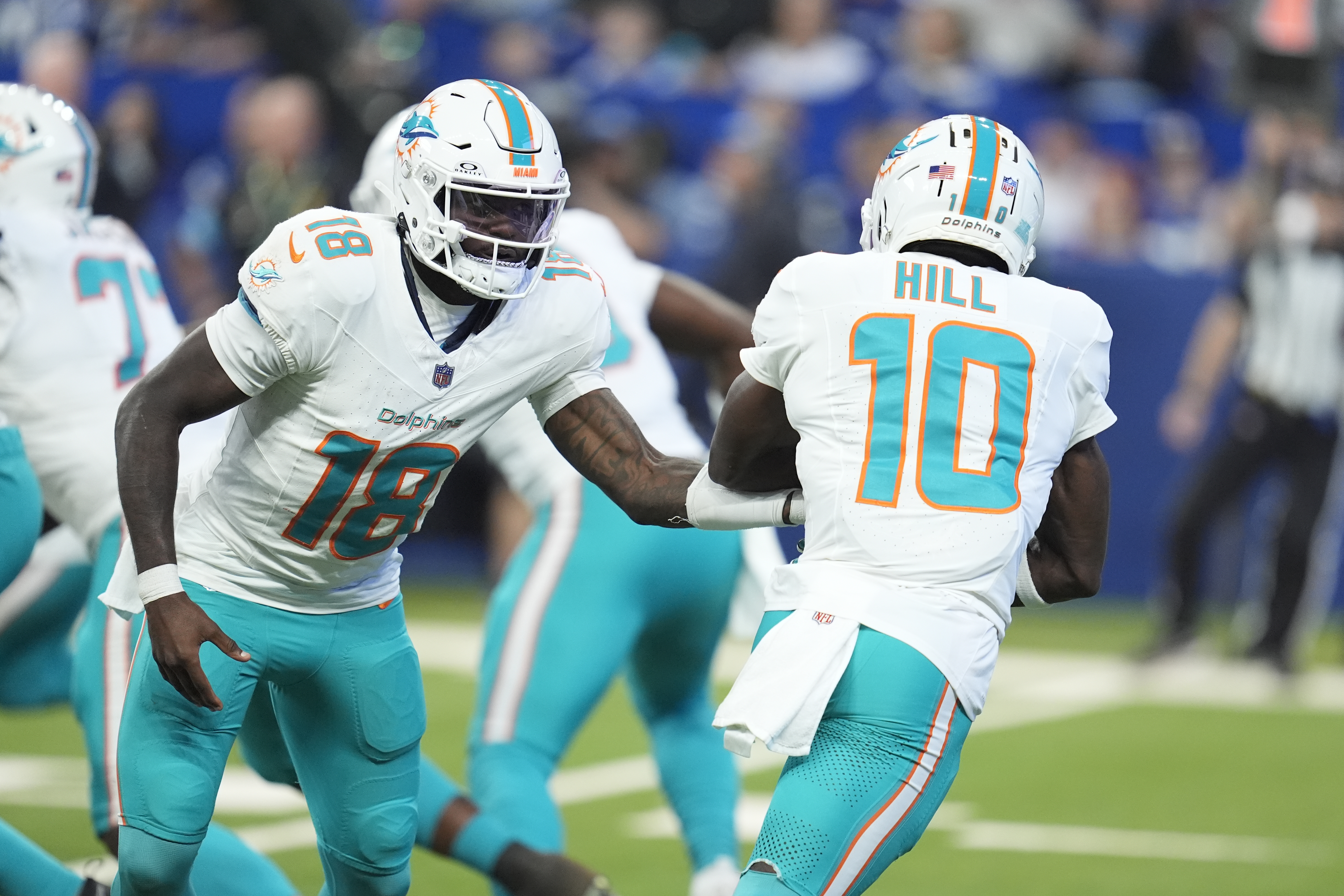 Miami Dolphins quarterback Tyler Huntley (18) hands off to wide receiver Tyreek Hill (10) during the first half of an NFL football game against the Indianapolis Colts, Sunday, Oct. 20, 2024 in Indianapolis.